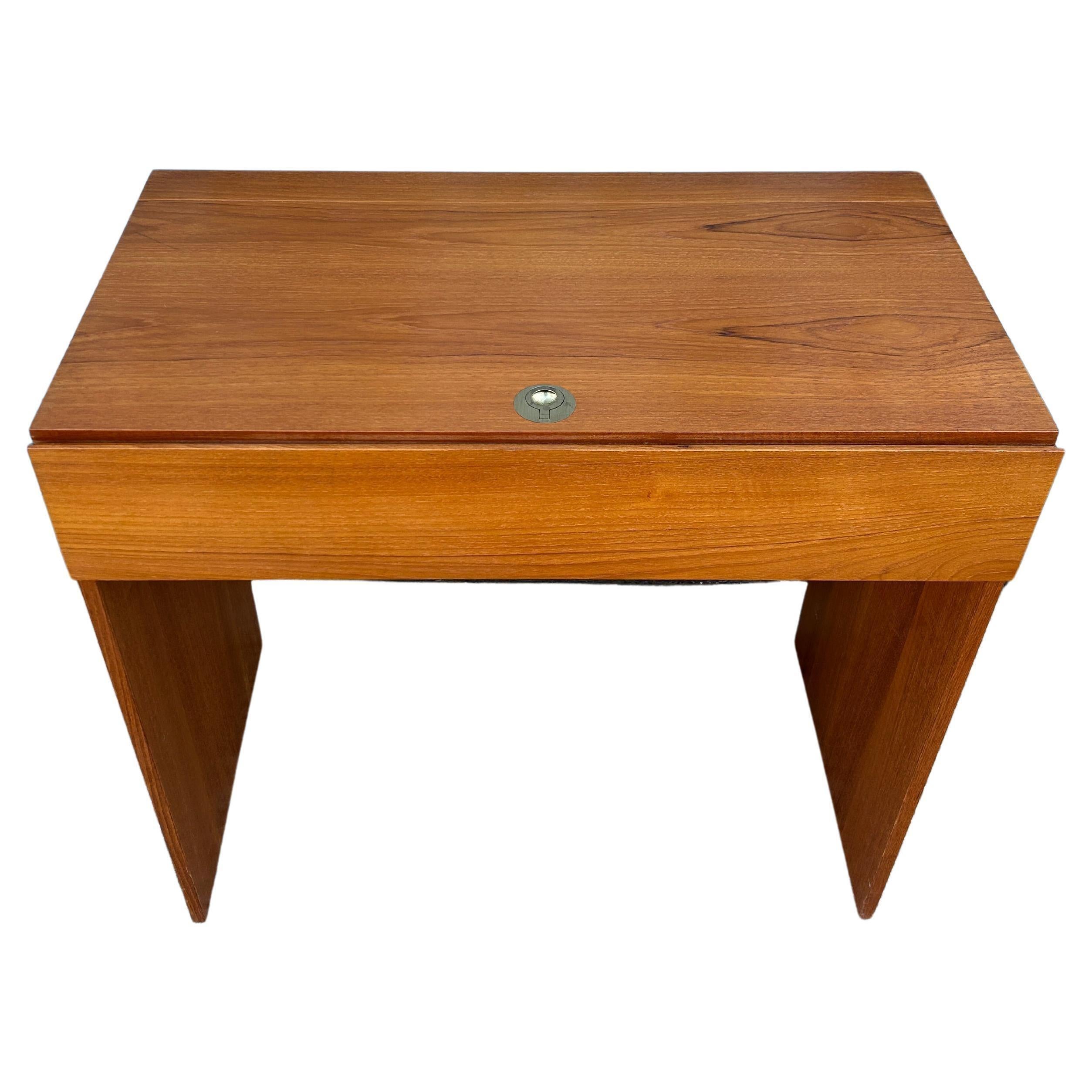 Tocador o escritorio de maquillaje de madera de teca de estilo moderno danés de mediados de siglo. Bonito color de teca clara con un bonito veteado. El espejo superior abatible con tirador de anilla de latón se abre a un joyero deslizante forrado de