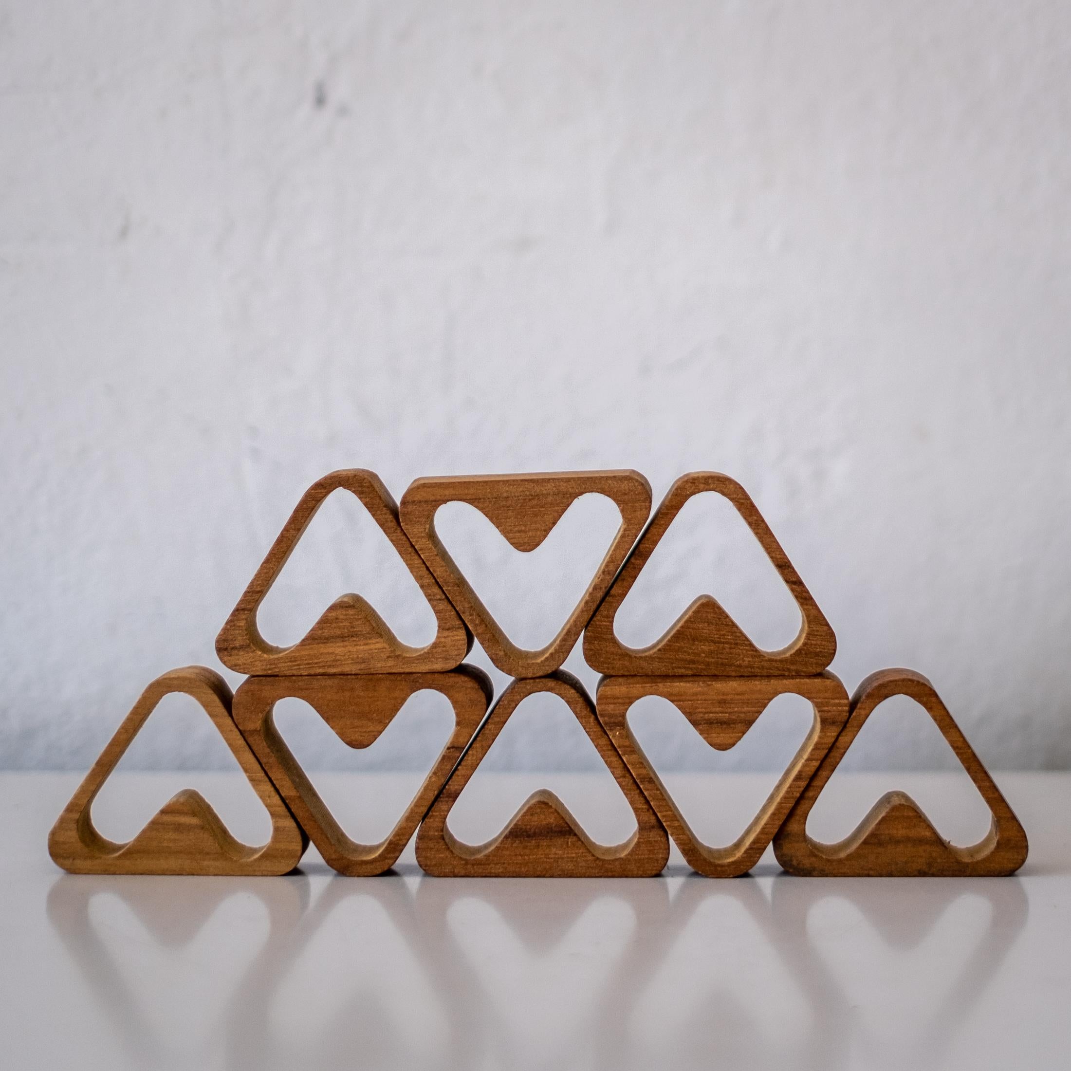 A set of eight sculptural napkin rings in teak, 1960s.