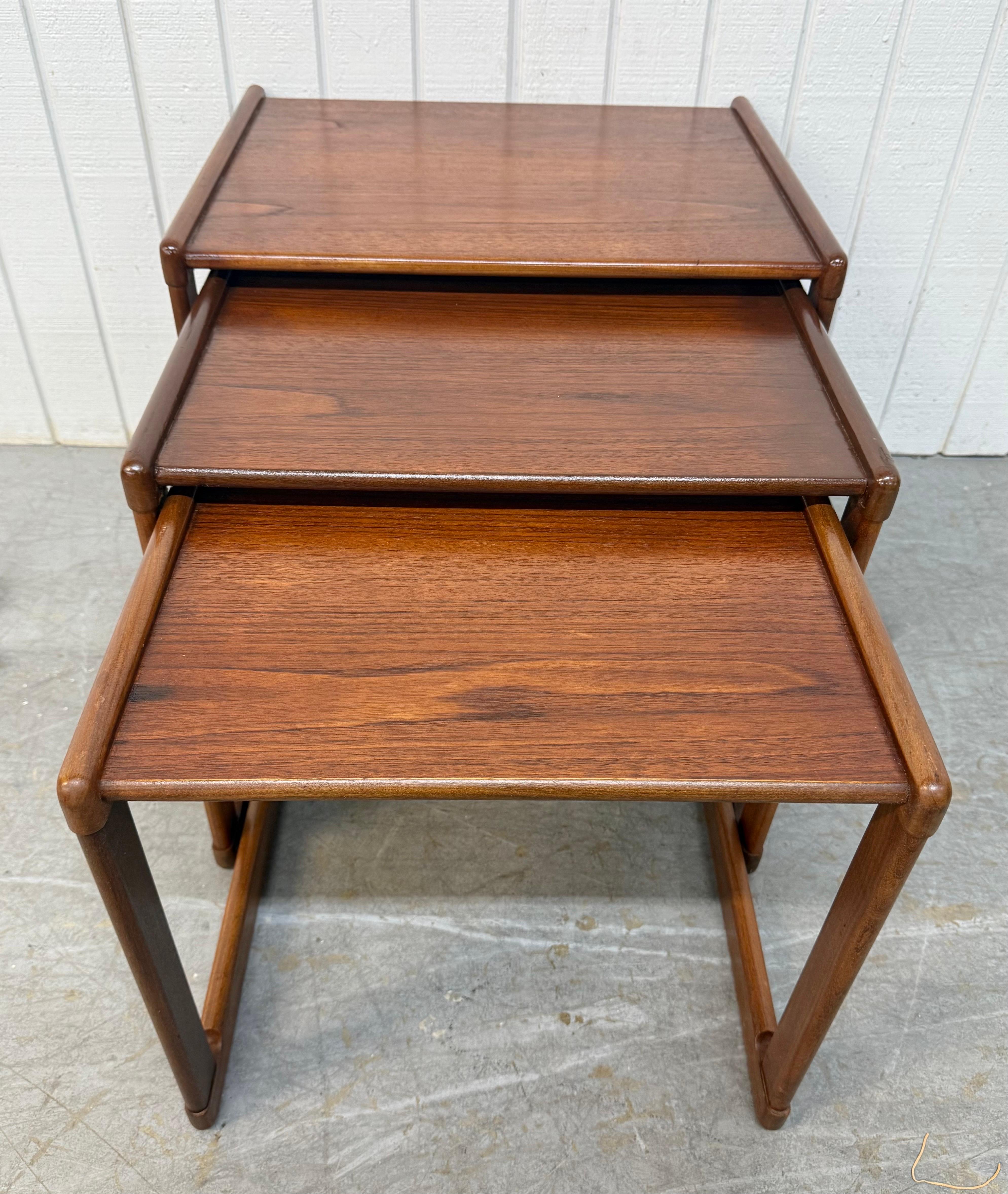 Cette annonce concerne un ensemble de trois tables gigognes en teck de style moderne danois du milieu du siècle dernier. Avec un design rectiligne, des plateaux rectangulaires, trois tables de tailles différentes qui s'emboîtent les unes dans les