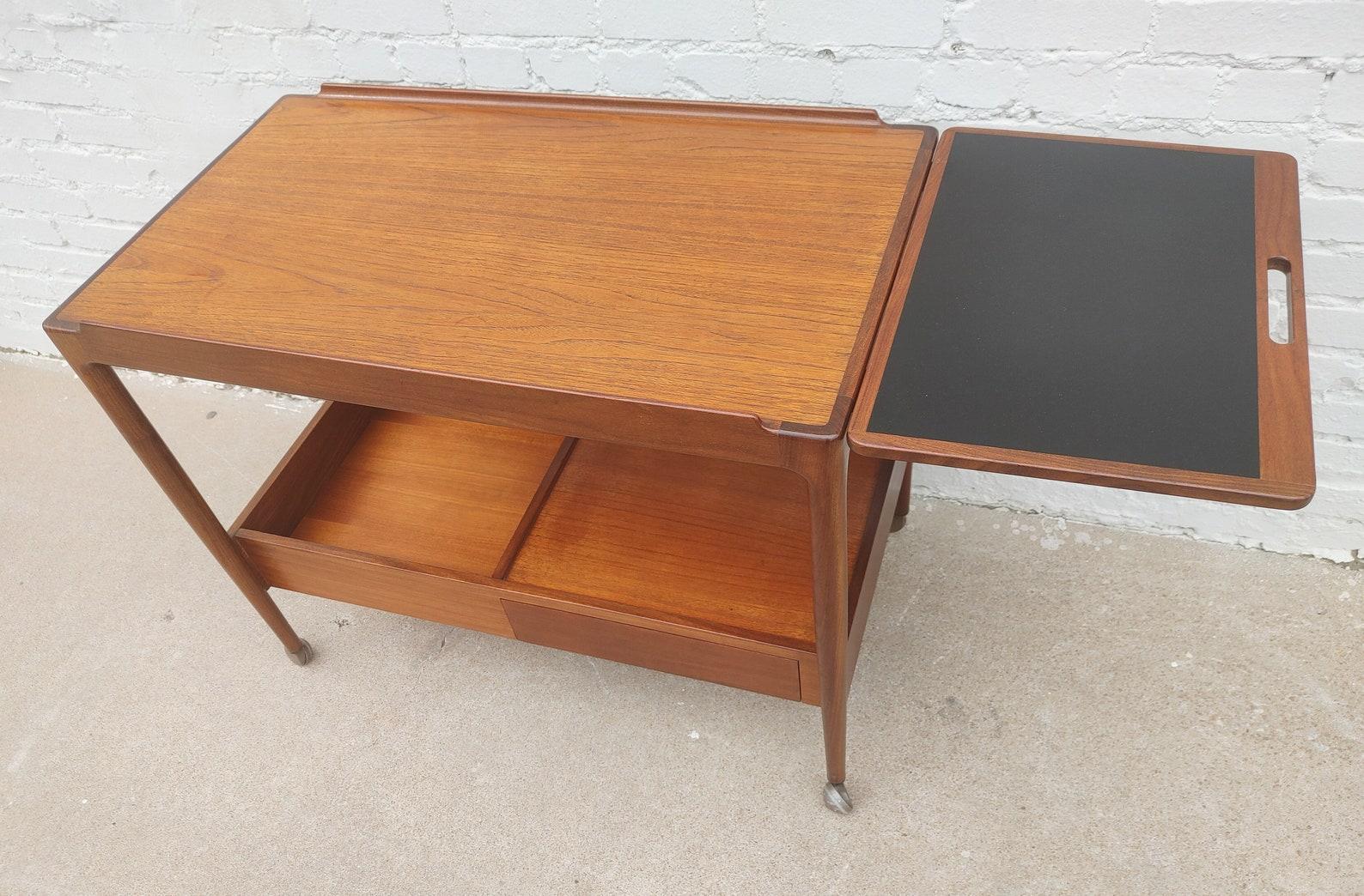 Mid Century Danish Modern Teak Rolling Bar by Kofod Larsen

Above average vintage condition and structurally sound. Has some expected slight finish wear and scratching. Outdoor listing pictures might appear slightly darker or more red than the item