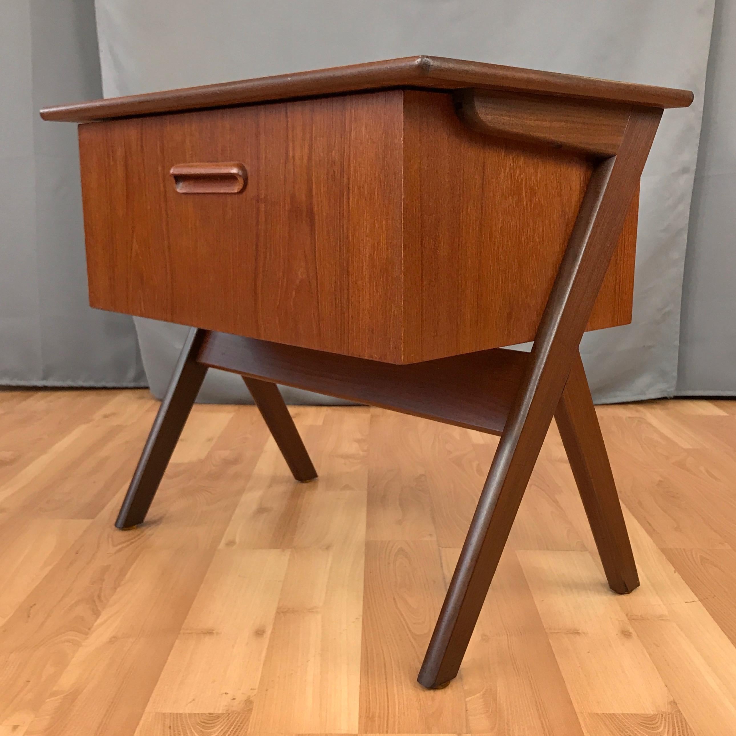 An uncommon 1960s Danish modern V-legged teak sewing box table that could also serve as a compact dry bar or versatile side table. 

Cantilevered top with deep, oversized drawer that pulls out and drops down to reveal a sliding multi-compartment