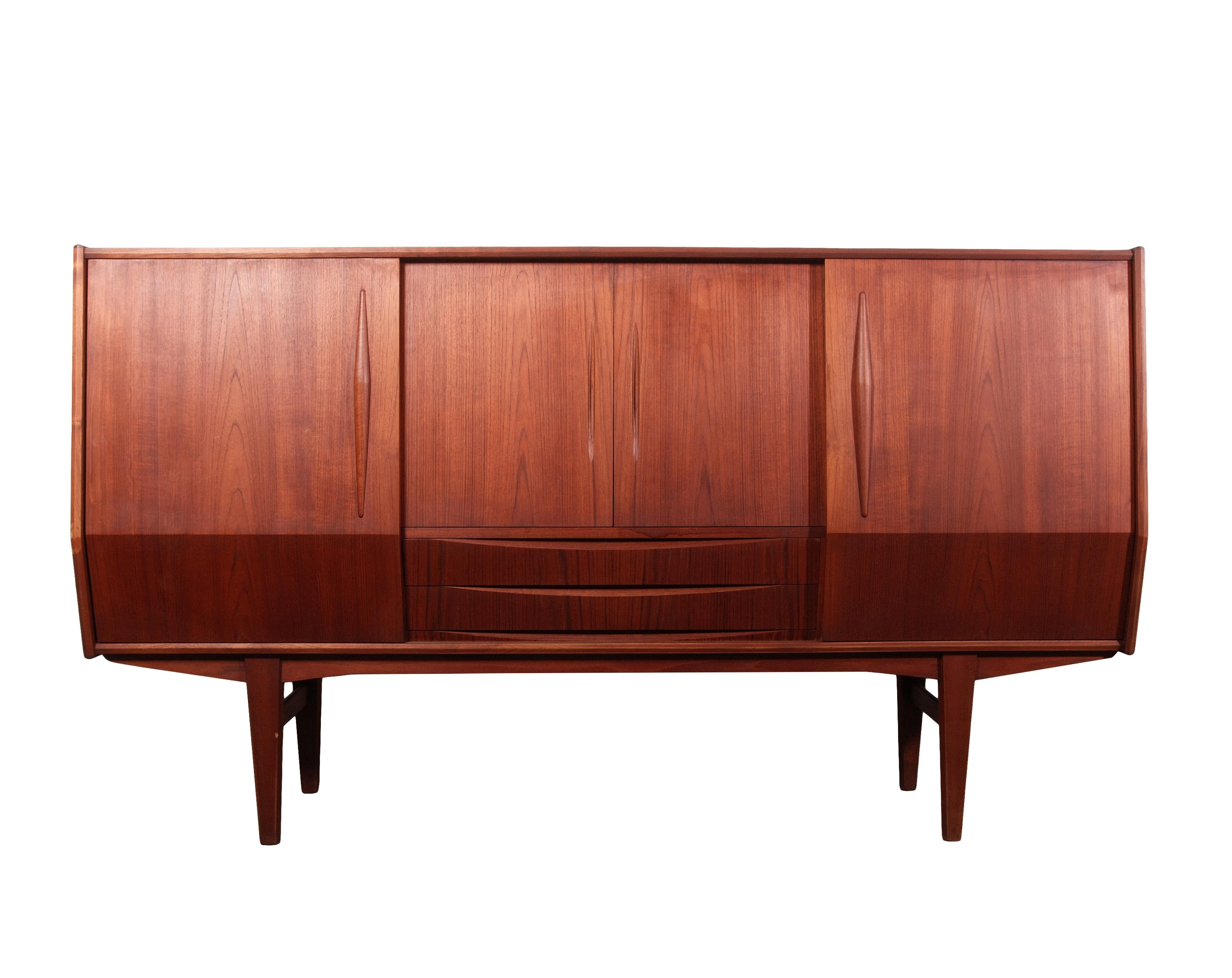 This versatile Mid-Century Danish Modern masterpiece piece is designed to serve as a sideboard, credenza, or dry bar, offering both functional elegance and sophisticated charm. The thoughtfully angled casing is enhanced by sleek sliding doors that