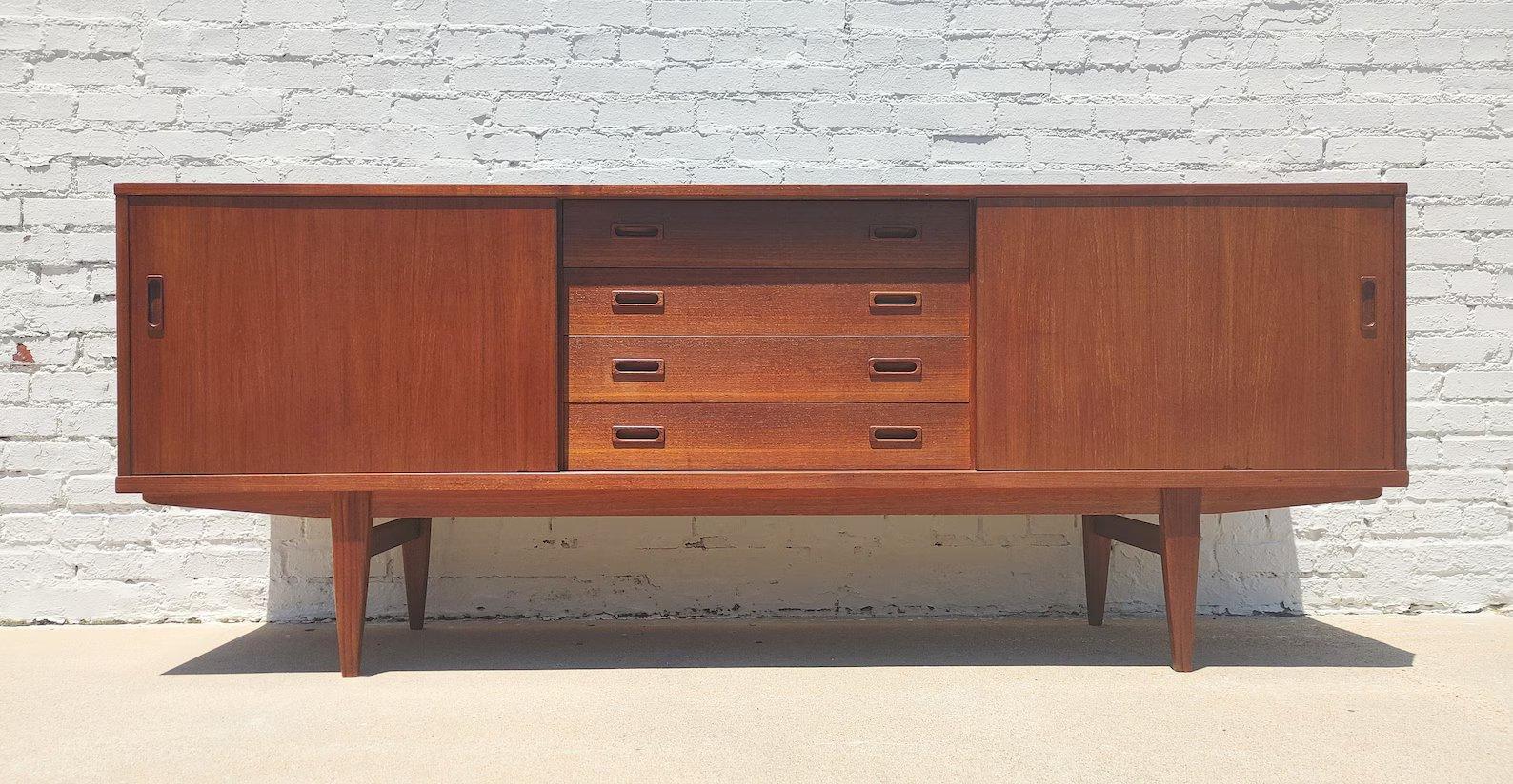Mid Century Danish Modern Teak Sideboard
 
Above average vintage condition and structurally sound. Has some expected slight finish wear and scratching. Top has been refinished and does not have original factory finish. Outdoor listing pictures might