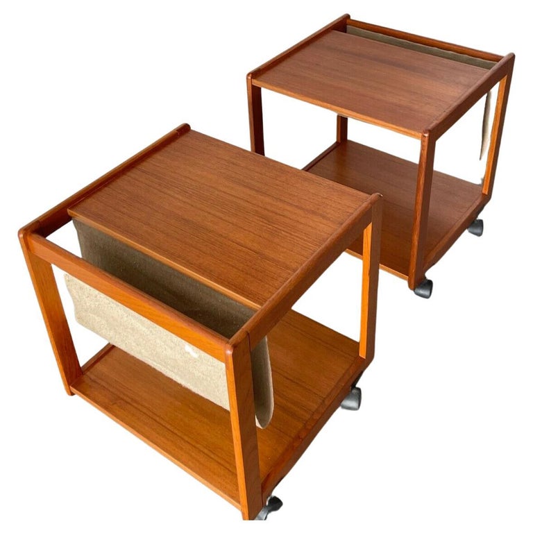 Danish modern teak magazine stand side table on casters by FBJ Møbler.

The rolling stand has a linen magazine pouch on one end of a solid teak table top with lower teak shelf for extra storage.

This is a versatile and solid piece of
