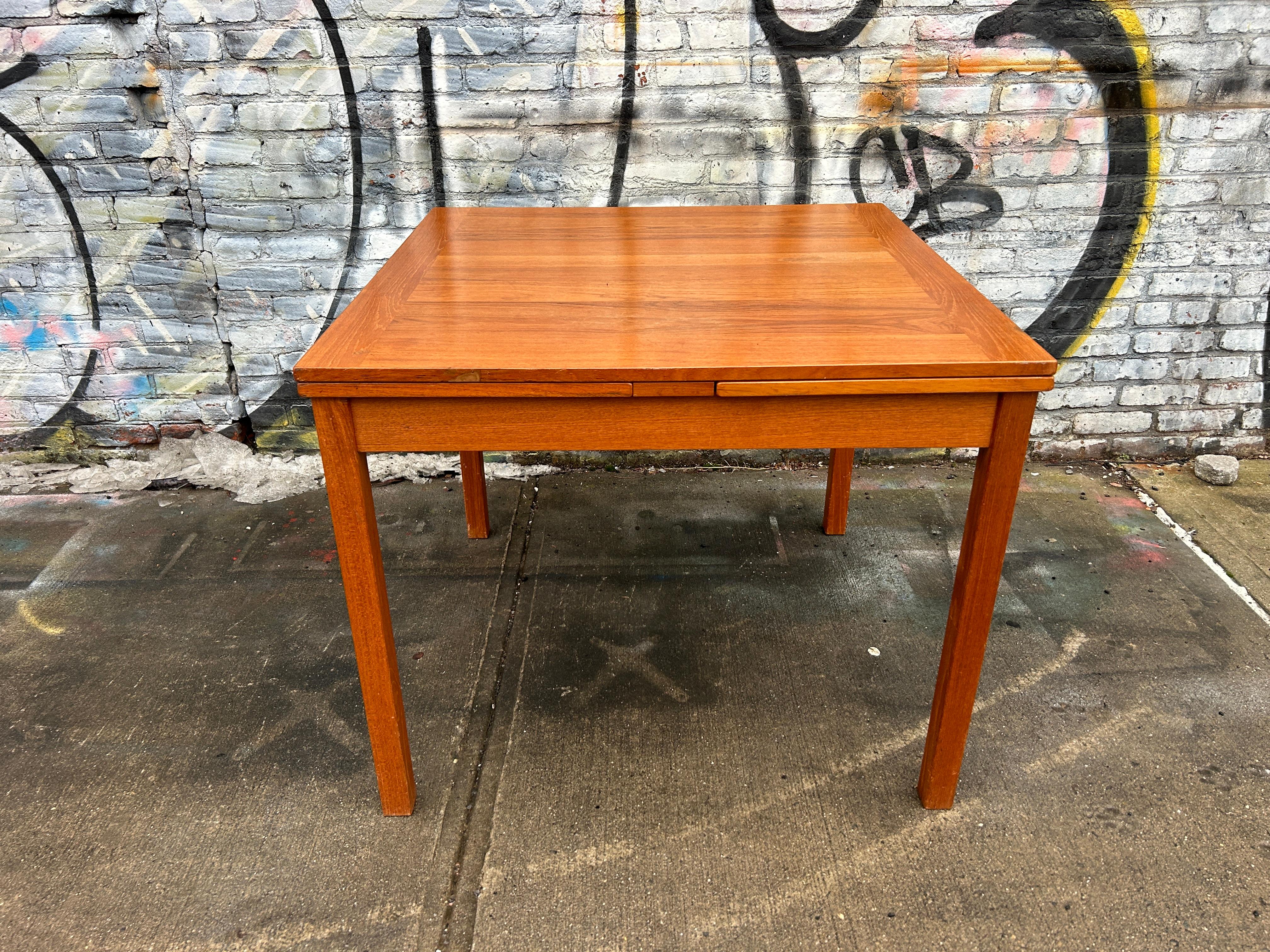 Mid century Danish Modern teak small square extension dining table By AM Mobler. Beautiful teak table that extends with (2) pull out leaves. Solid teak square legs with a square table top 36” x 36” x 29”.  Made in Denmark by AM Mobler. Located in