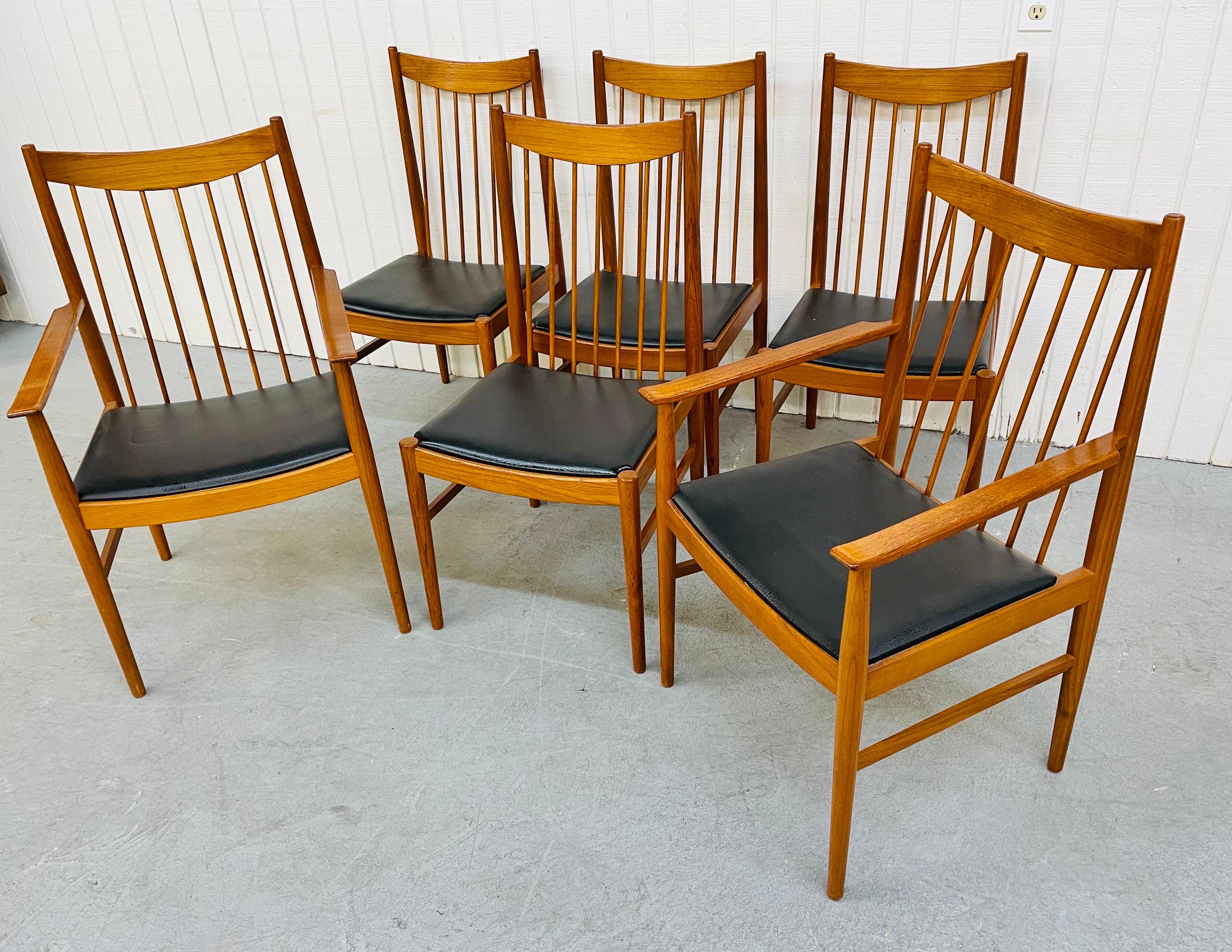 This listing is for a set of six midcentury Danish Modern teak spindle dining chairs. Featuring four straight chairs, two arm chairs, spindle backs, original black vinyl upholstery, curved back rest tops, and a beautiful teak finish.