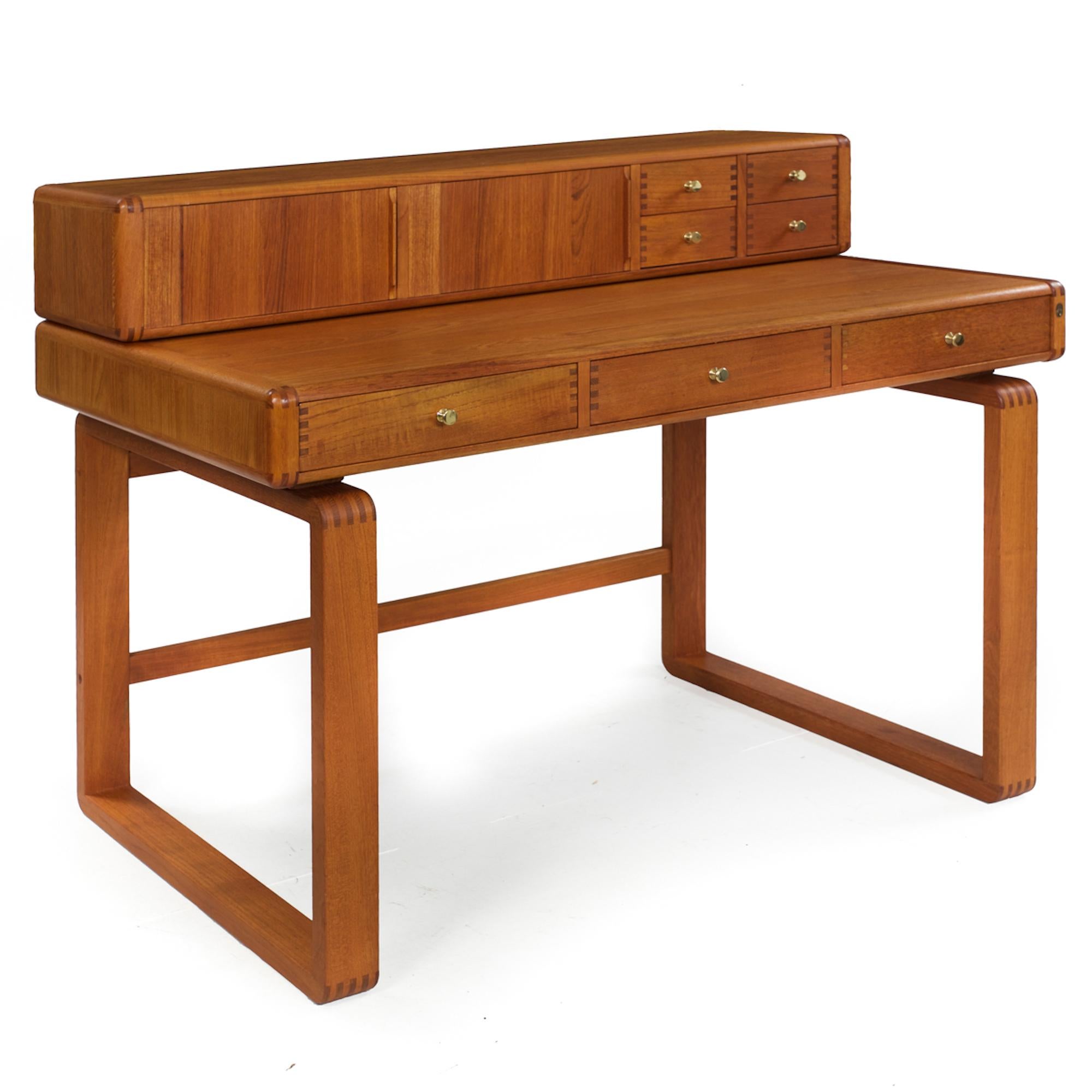 A very nice two-piece solid teak desk by D-Scan, it is crafted in two entirely separate units out of solid teak and teak veneers. The heavy finger-joint corners make for an incredibly solid construction. The top features tambour doors, the left door