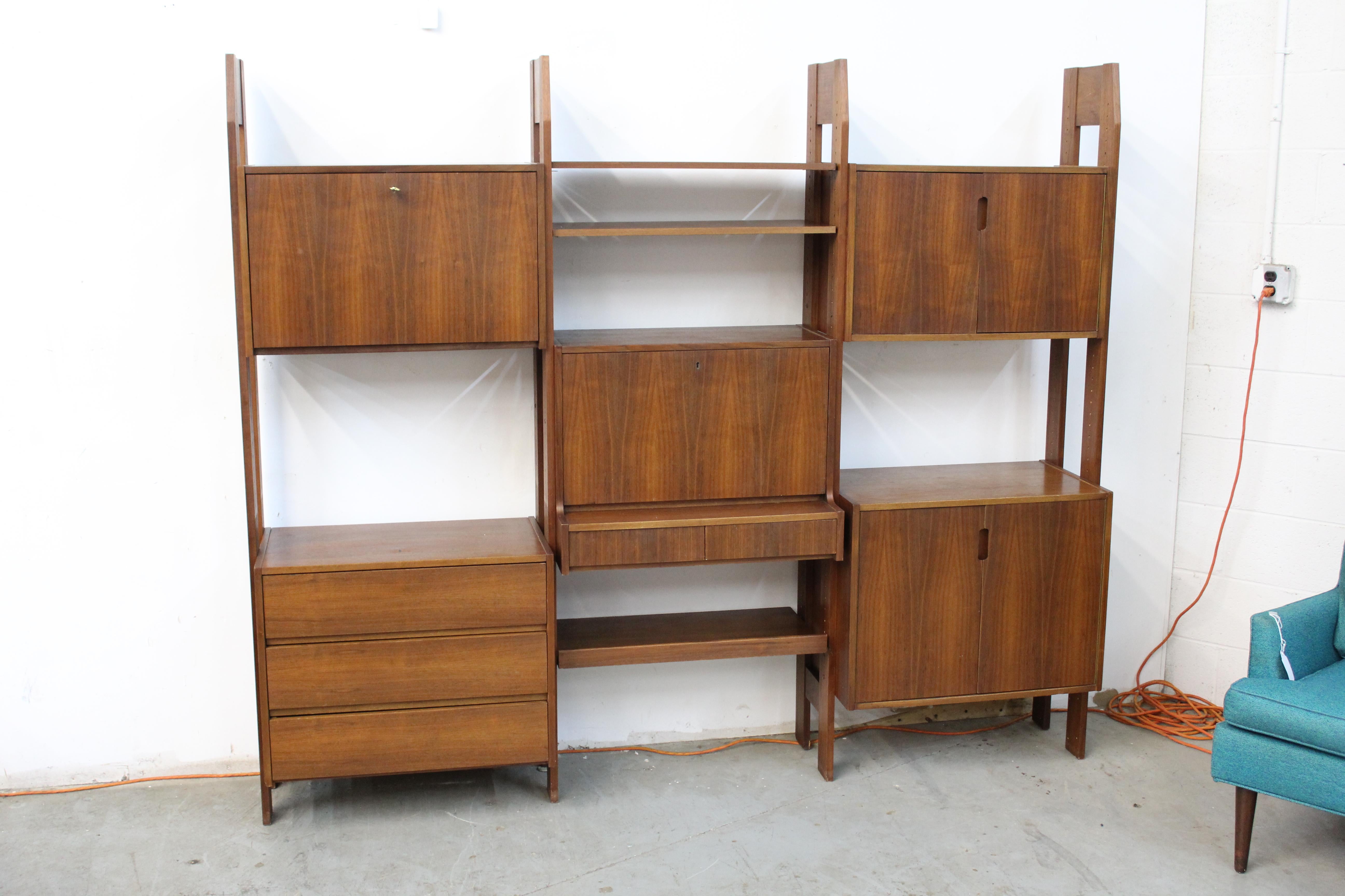 Mid-Century Danish Modern Teak Wall Unit System
Offered is a beautiful Danish Modern teak wall unit. This wall unit is slightly unique in that it is free standing and requires no wall mounts or attachments.  It features three sections of drawers and