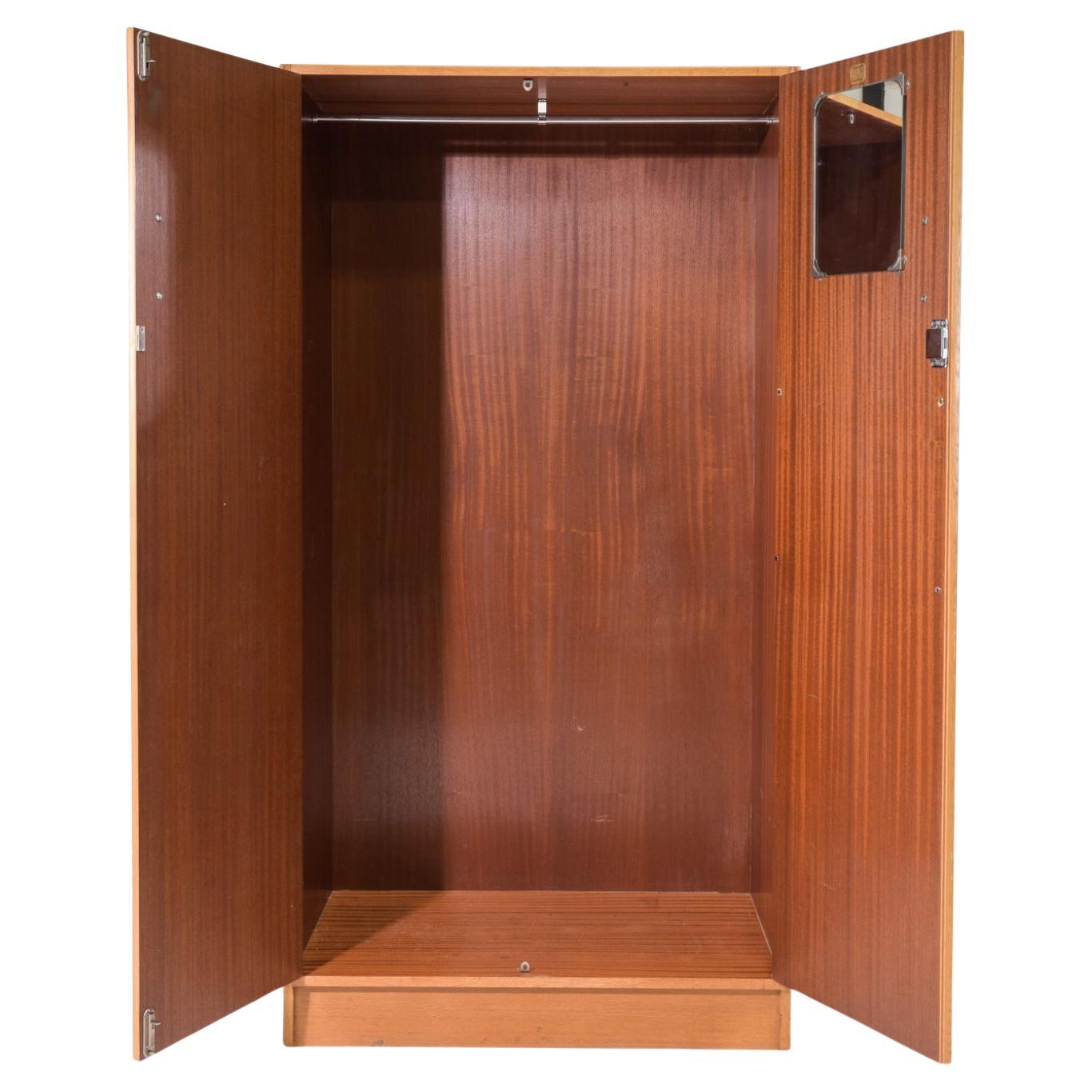 Armoire haute en teck moderne du milieu du siècle. Elle est équipée de 2 portes avant coulissantes et d'un miroir intérieur. Tout l'intérieur est ouvert avec une barre de suspension pour les vêtements. Poignées en teck sur le devant. Grain de bois