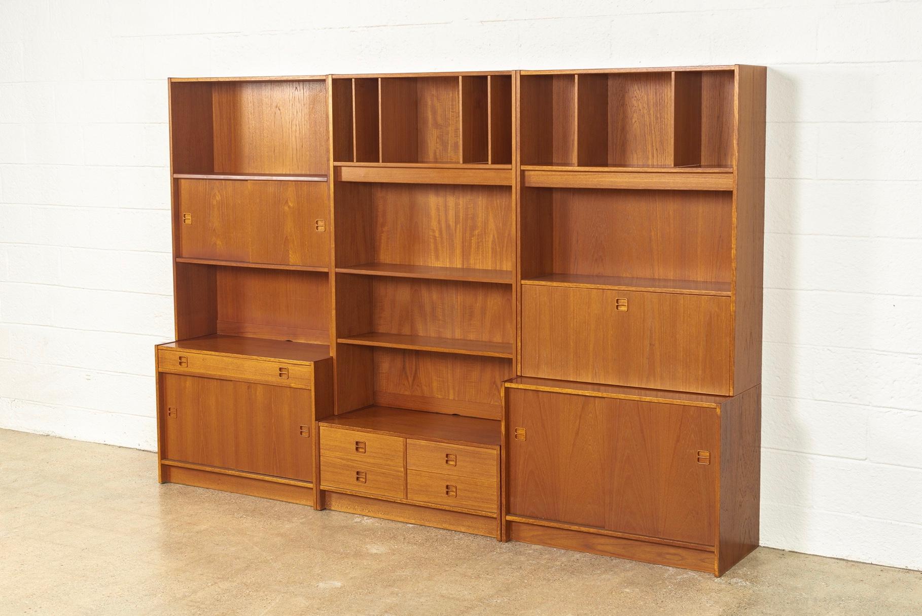 This vintage midcentury Danish modern teak bookcase shelving system is comprised of three units and was made in Denmark, circa 1970. The Classic Danish modern design has clean, Minimalist lines and is well-crafted from teak. Highly versatile and