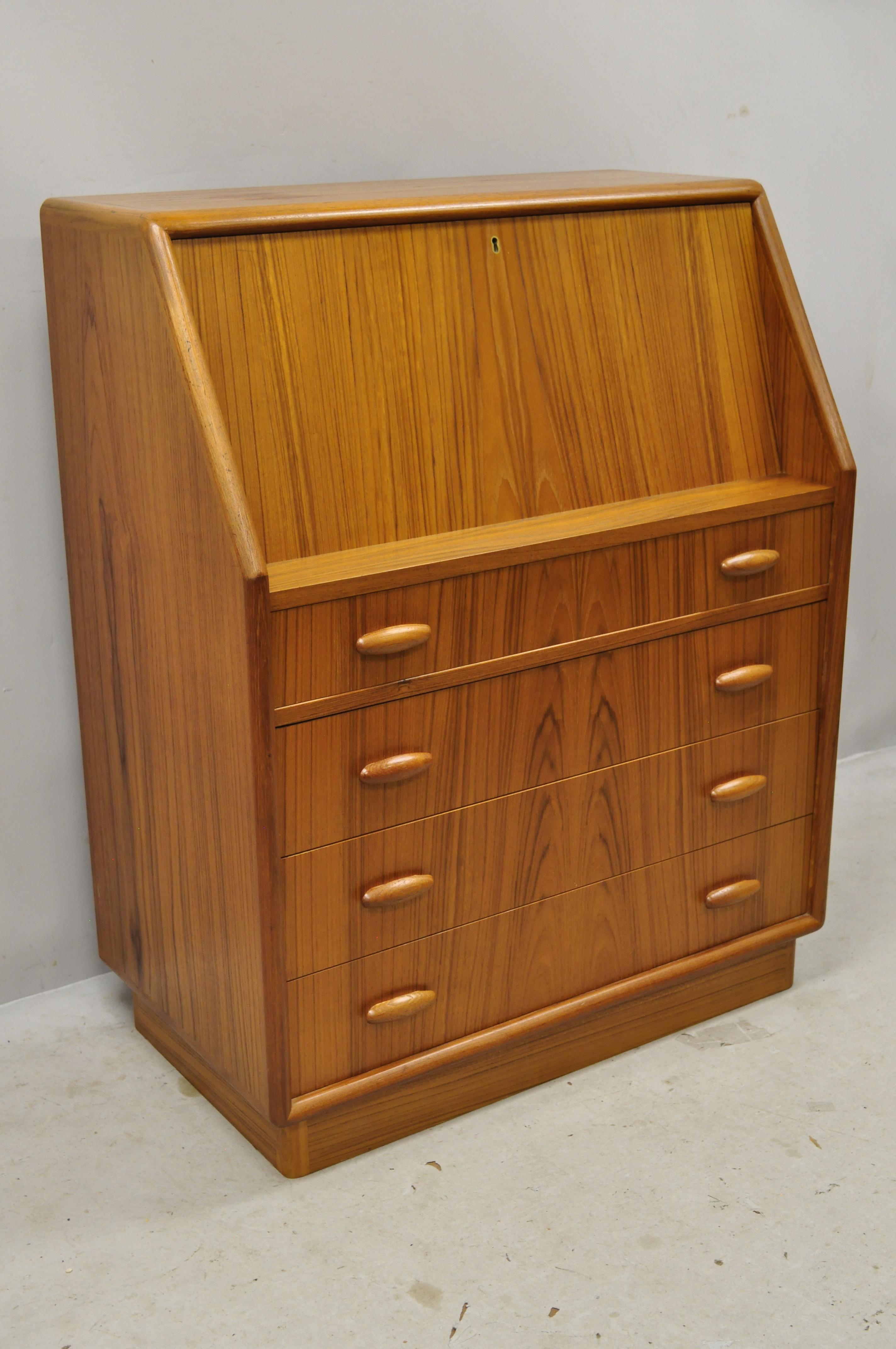 Midcentury Danish modern teak wood slant fall front secretary desk cabinet. Item features fitted interior, fall front, sculpted wood pulls, beautiful wood grain, working lock and key, quality Danish craftsmanship, great style and form, circa 1960s.