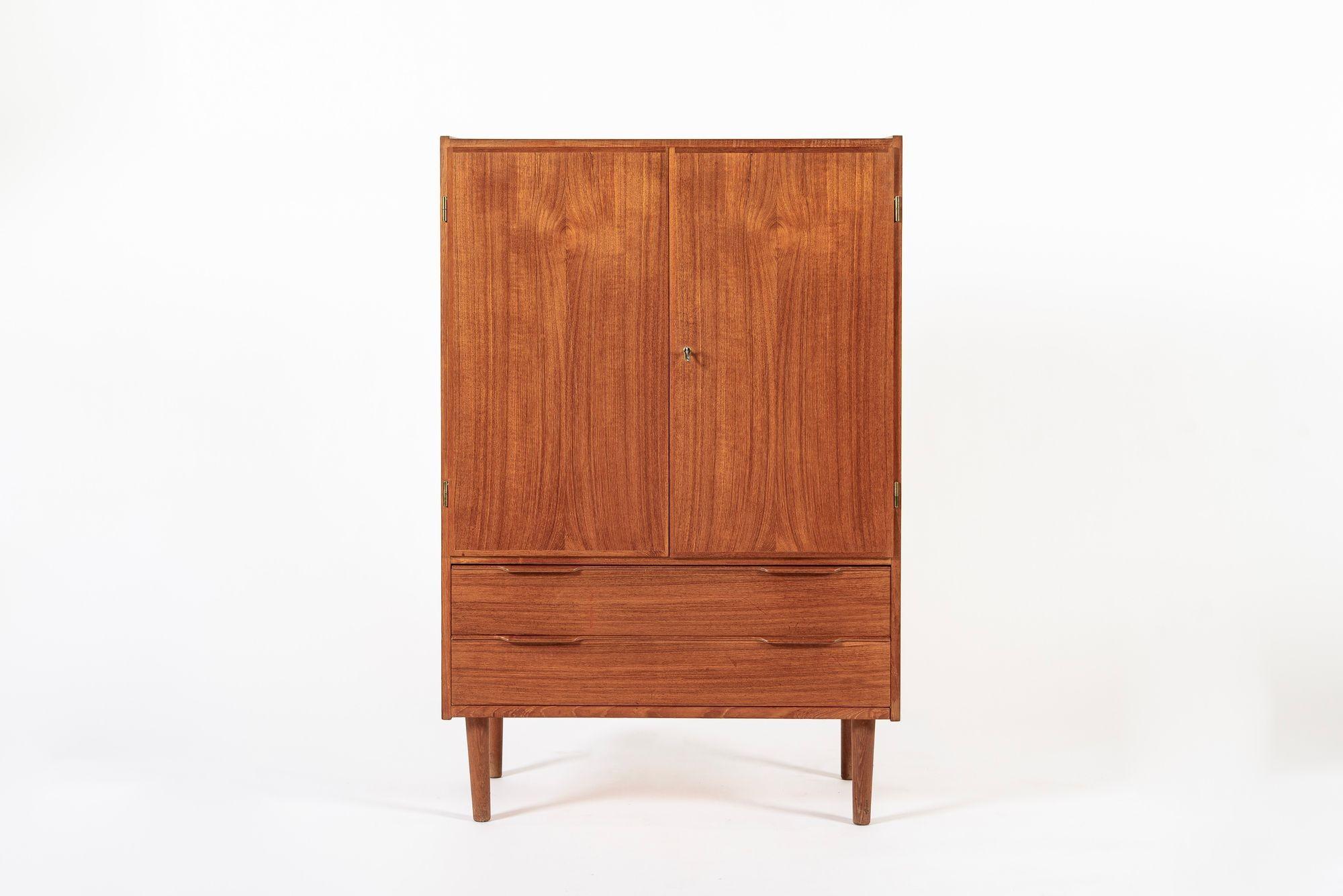 This vintage mid century Danish modern teak wood storage or bar cabinet was made in Denmark circa 1960. The classic Scandinavian design has clean, minimalist lines and an elegant, geometric proportion and the cabinet is well-crafted from teak wood