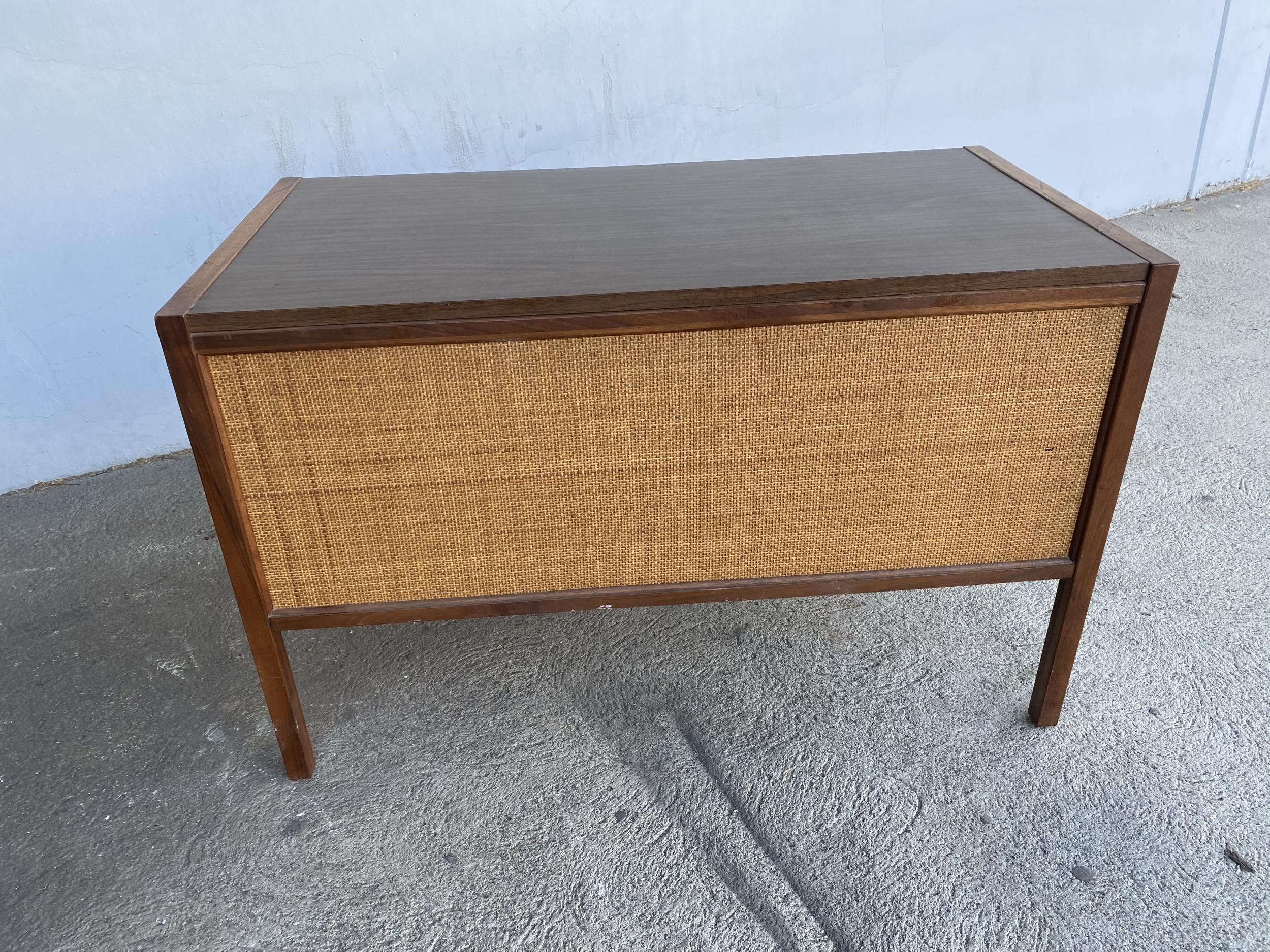 Original 1960s Danish modern style teak writing desk with woven wicker front and dark stained carved teak drawer pulls. The desk features 6 pull out drawers.

Branded: Sligh Lowry.