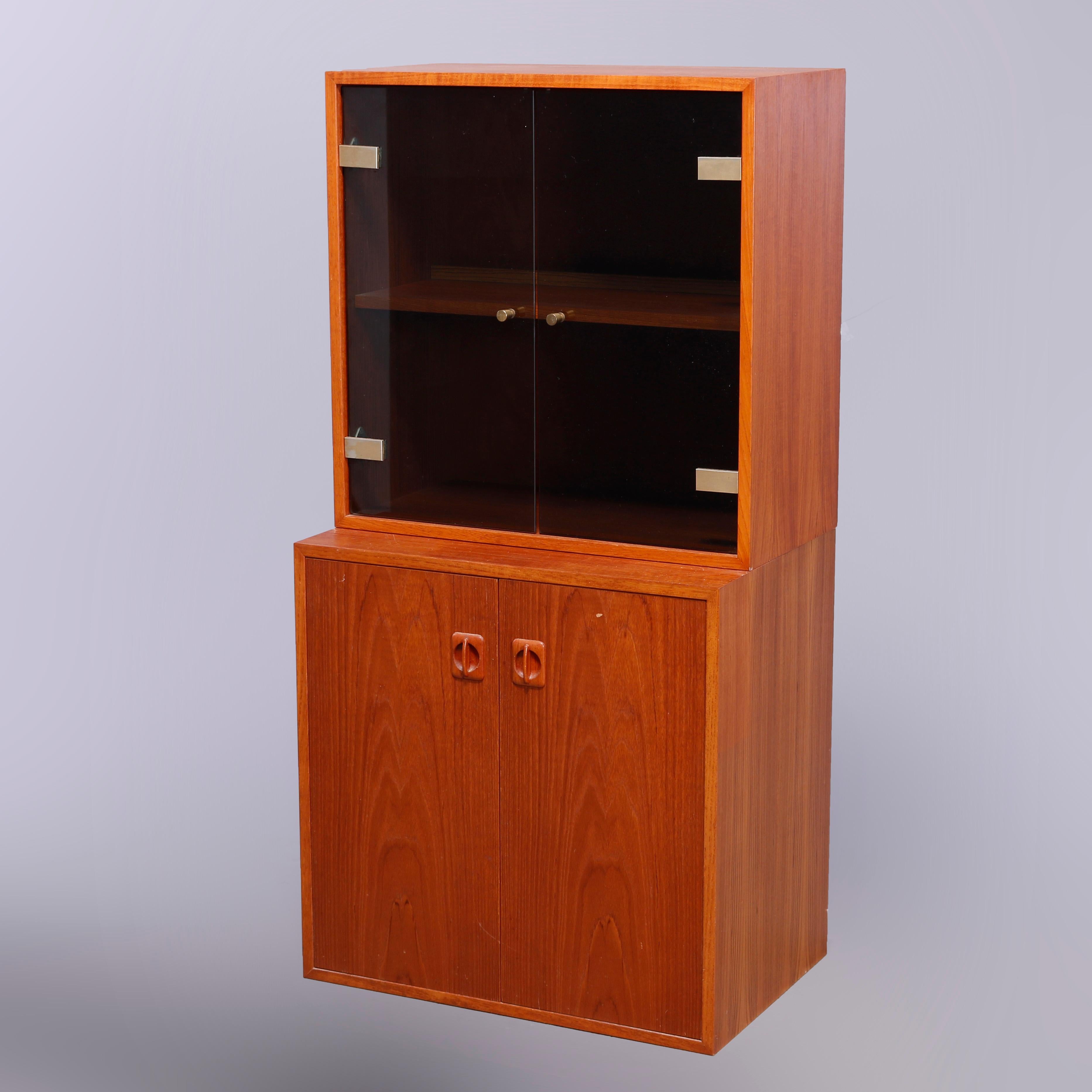 A Mid Century Danish Modern cabinet offers upper with glass doors opening to shelved interior and surmounting lower blind door cabinet, Denmark label as photographed, c1960

Measures - 47.5'' H x 23.75'' W x 15.75'' D.