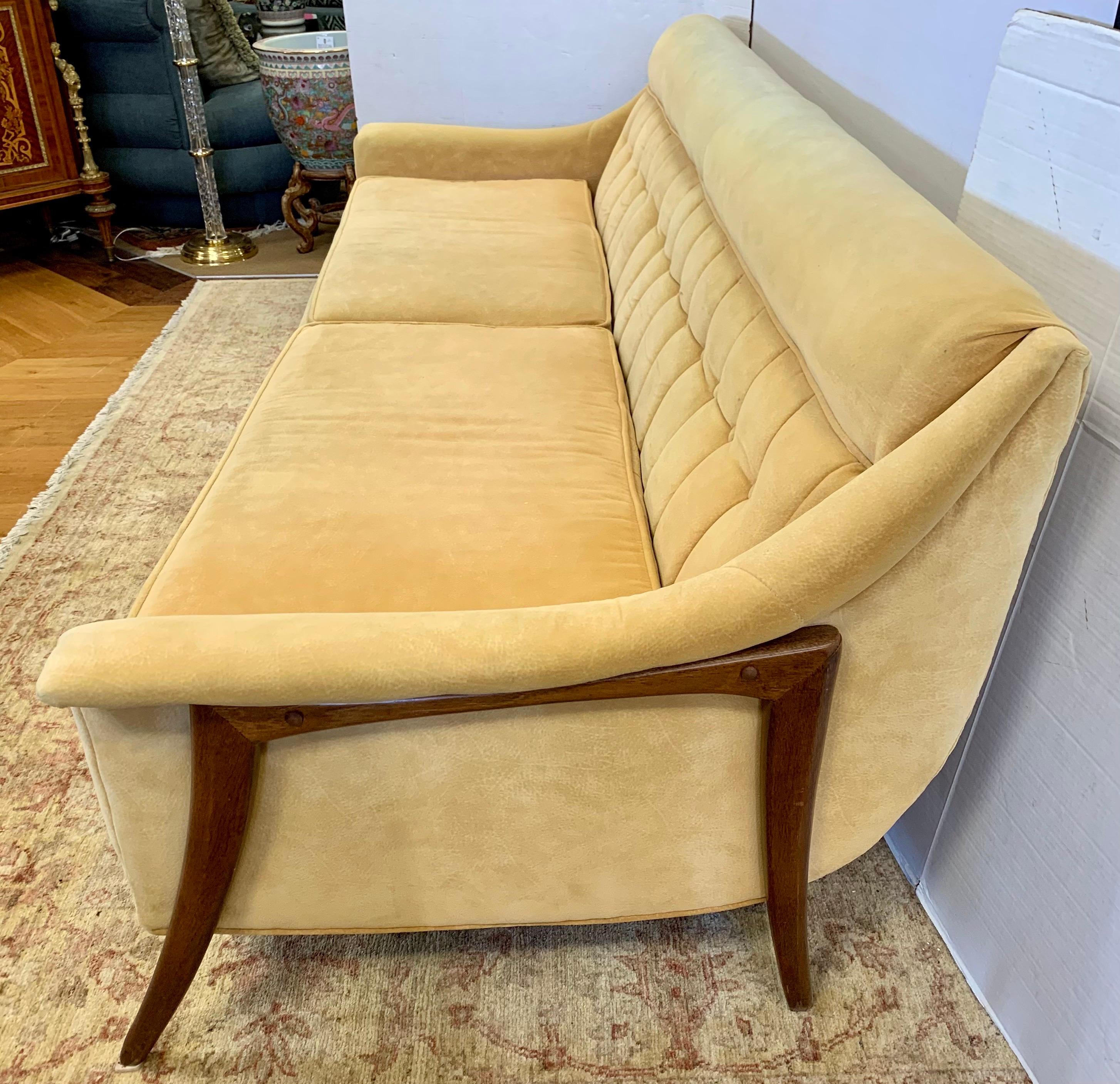 Stunning Danish modern sculptural sofa with walnut boomerang like supports and original straw colored ultra suede fabric. Elegant button tufted backrests. Great scale at 86