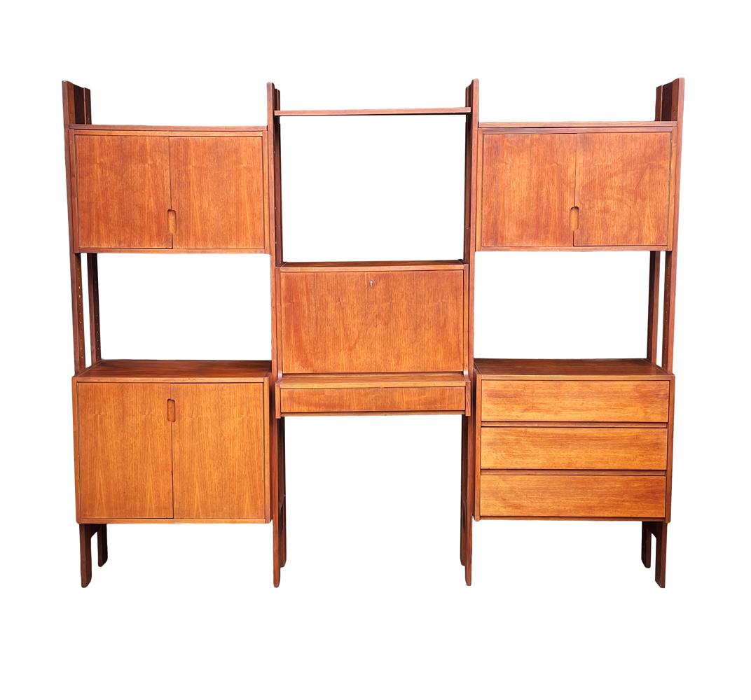 A large Scandinavian wall unit circa 1960's. It features teak wood finish with a drop down center desk. The unit is totally modular and can arranged to your liking. It also includes interior shelving not shown in photos.