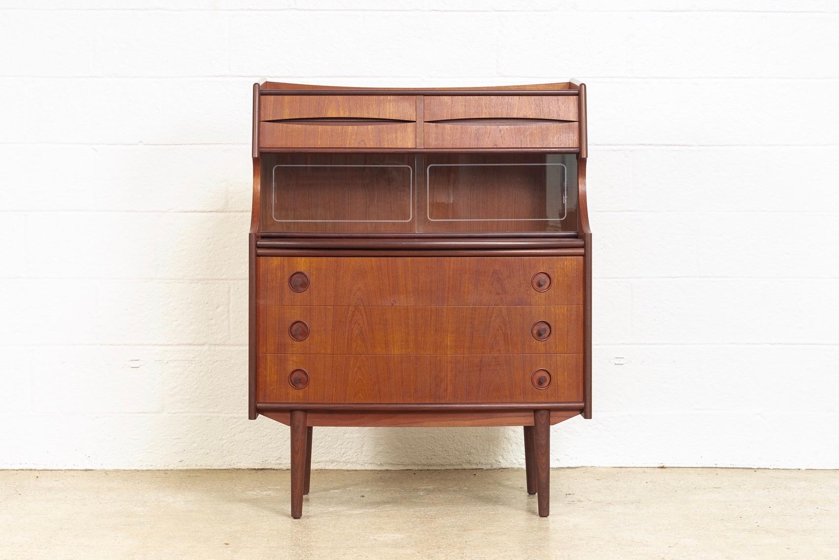 This unique midcentury Danish modern walnut wood secretary desk is, circa 1960. The Classic Scandinavian Modern design has clean Minimalist lines and gentle curves. The rich medium brown walnut wood has beautiful grain and is two-toned with darker