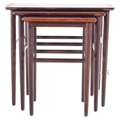 Presented is a set of three Mid-Century Modern nesting tables, exuding an air of refined sophistication and practical design. Crafted from sumptuous rosewood, each piece showcases a rich, warm hue and a distinctive grain pattern that promises to