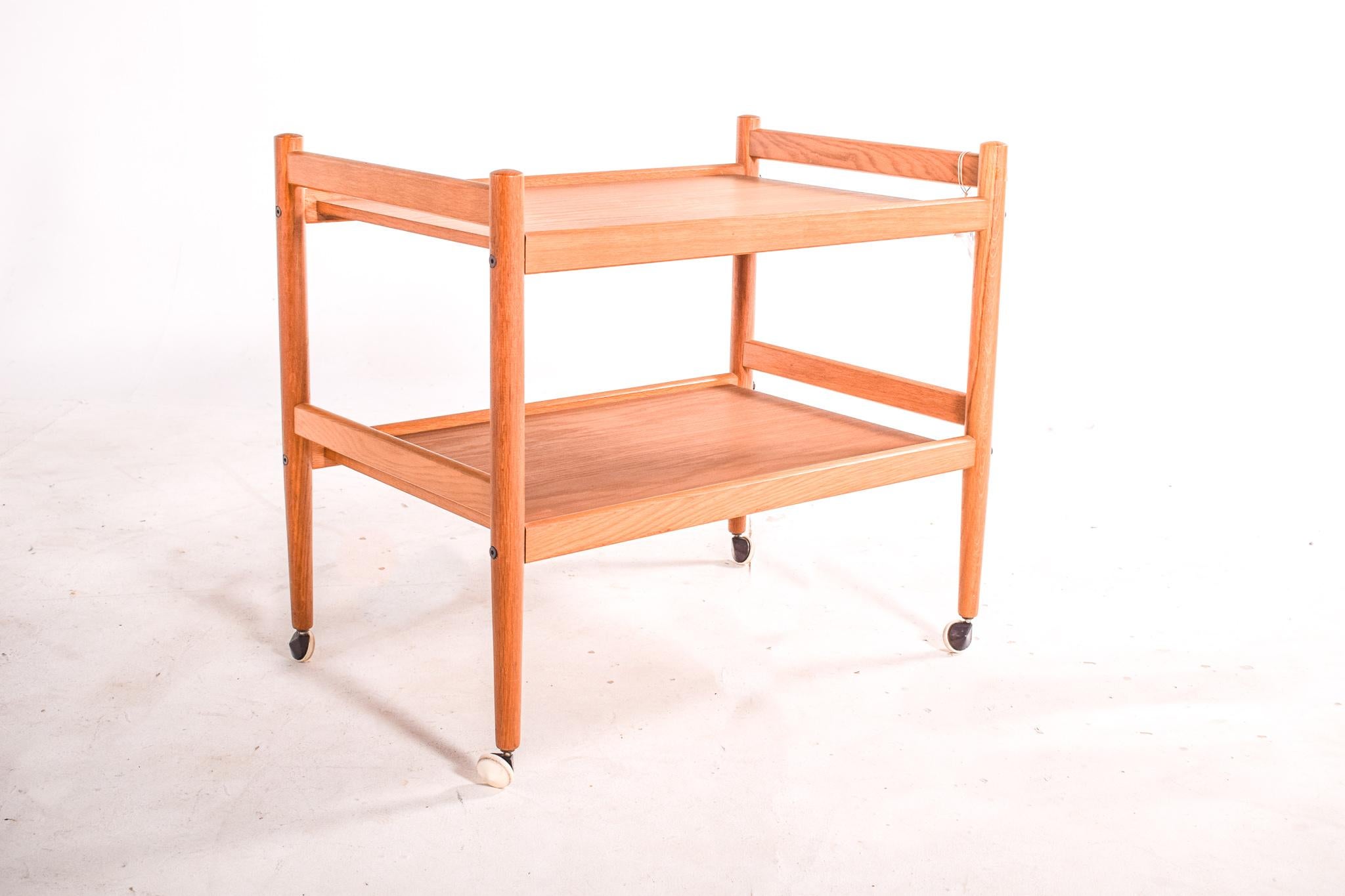 Midcentury oak bar cart/tea trolley produced in the 1950s. Original retro Danish Scandinavian style. This vintage original trolley hails from Denmark and is representative of the simplicity of Danish design. Crafted in solid and veener oak wood.