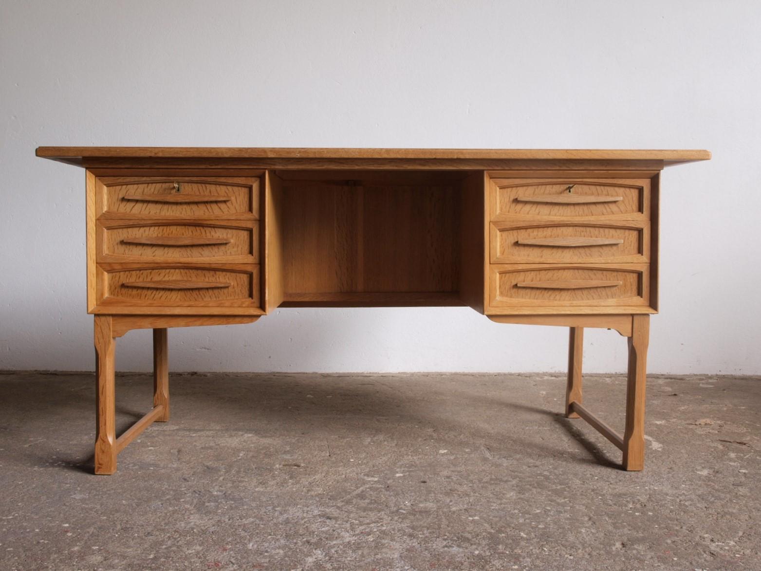 Solid oak writing desk complete with drawers, attributed to Danish furniture designerHenning Henry Kjærnulf, a compelling piece. This creation harmoniously blends bold Baroque elements with the finesse of Mid-Century Modernism, resulting in a design