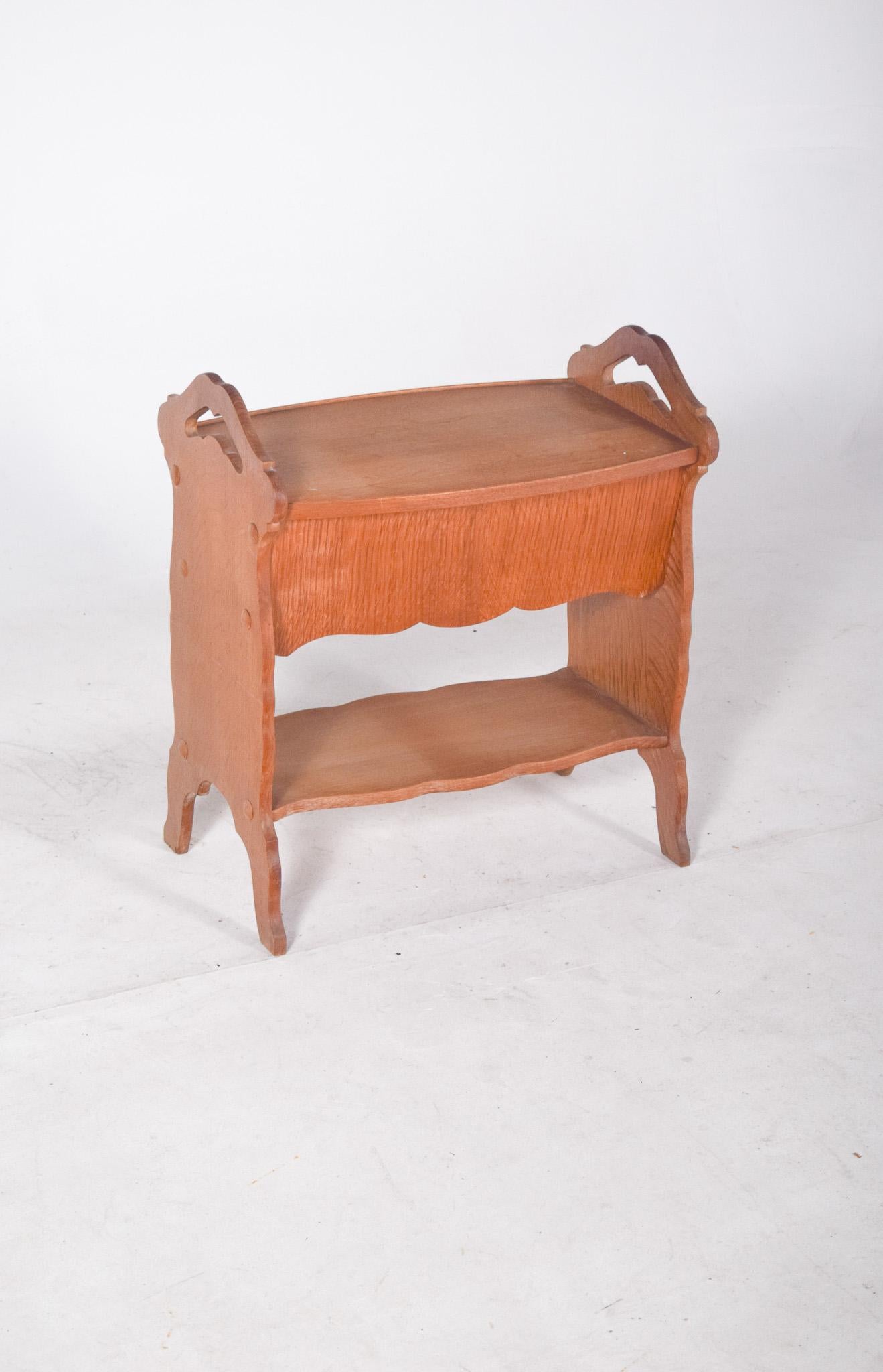 Etagère de couture en chêne. Compact et fonctionnel, il est idéal pour ranger le matériel de couture et les petits objets. La pièce comporte un compartiment supérieur avec un couvercle à charnière qui, lorsqu'il est ouvert, révèle diverses niches