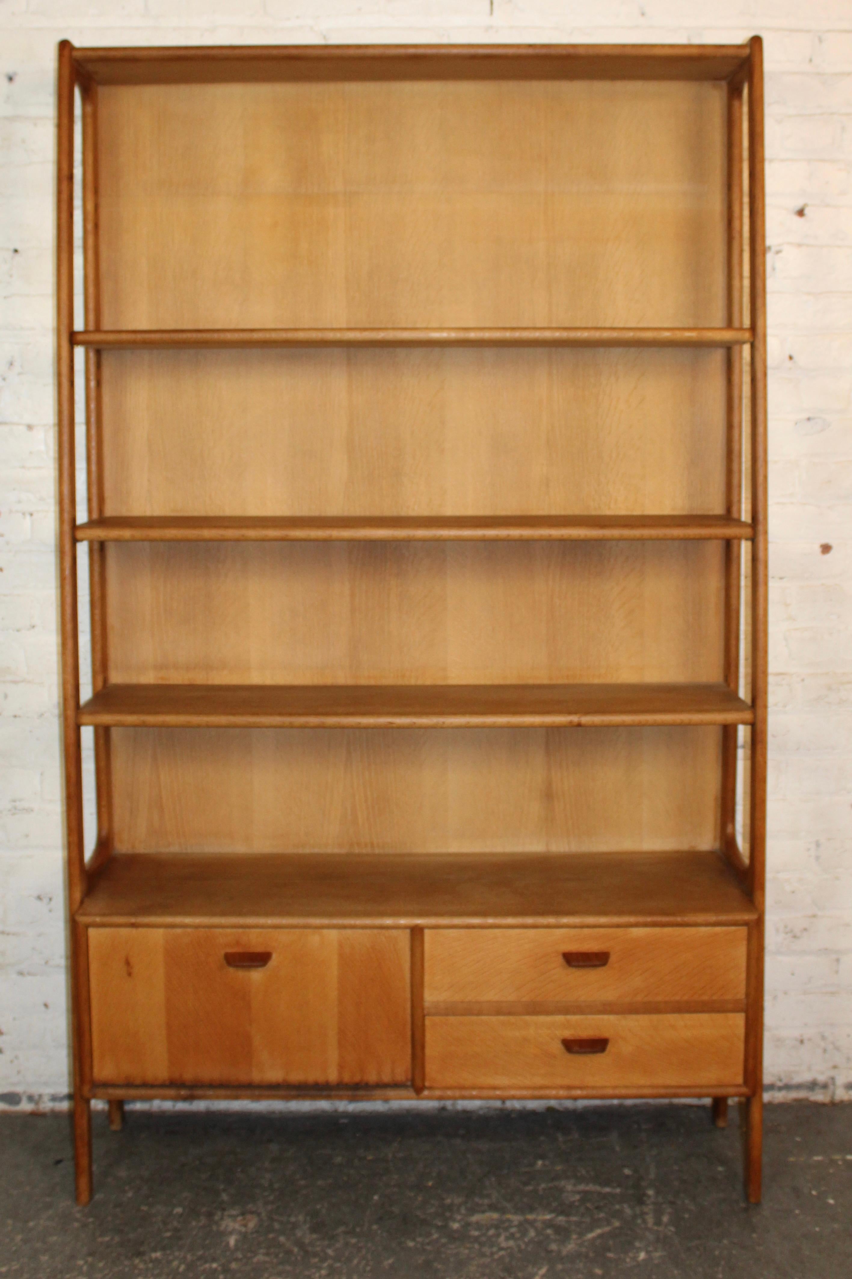 Elegante y funcional mueble alto de estilo moderno danés diseñado por Poul Volther. Fabricada en roble macizo y chapado, esta estantería alta tiene unos esculturales soportes laterales y cuatro estantes abiertos ajustables sobre un mueble inferior