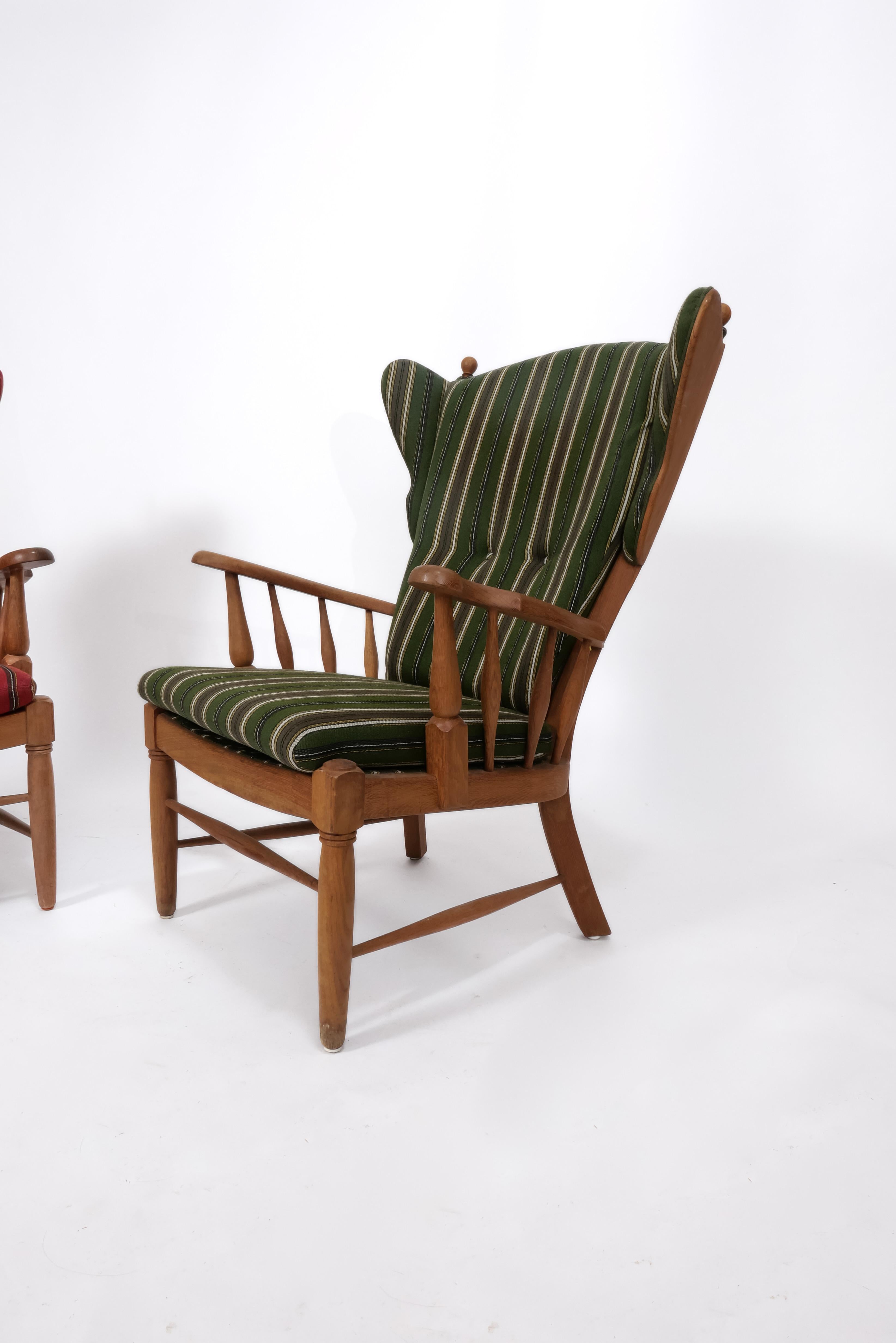 Unique pair of carved Oak lounge chairs, recently imported from Denmark. High backrests make these ultra comfortable for use as fireside chairs or in a sitting room. With whimsical detailing throughout, these chairs are statement-making. They are