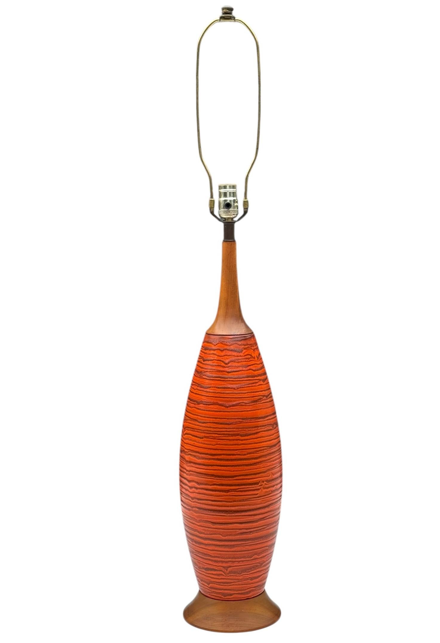 A stately glazed ceramic Mid-Century Modern table lamp. A beautiful orange and brown color palette. Tested, fully working and very well cared for through the years. Lamp shade not included. 

In the style of: Aldo Londi, Bitossi, Raymour, Rosenthal