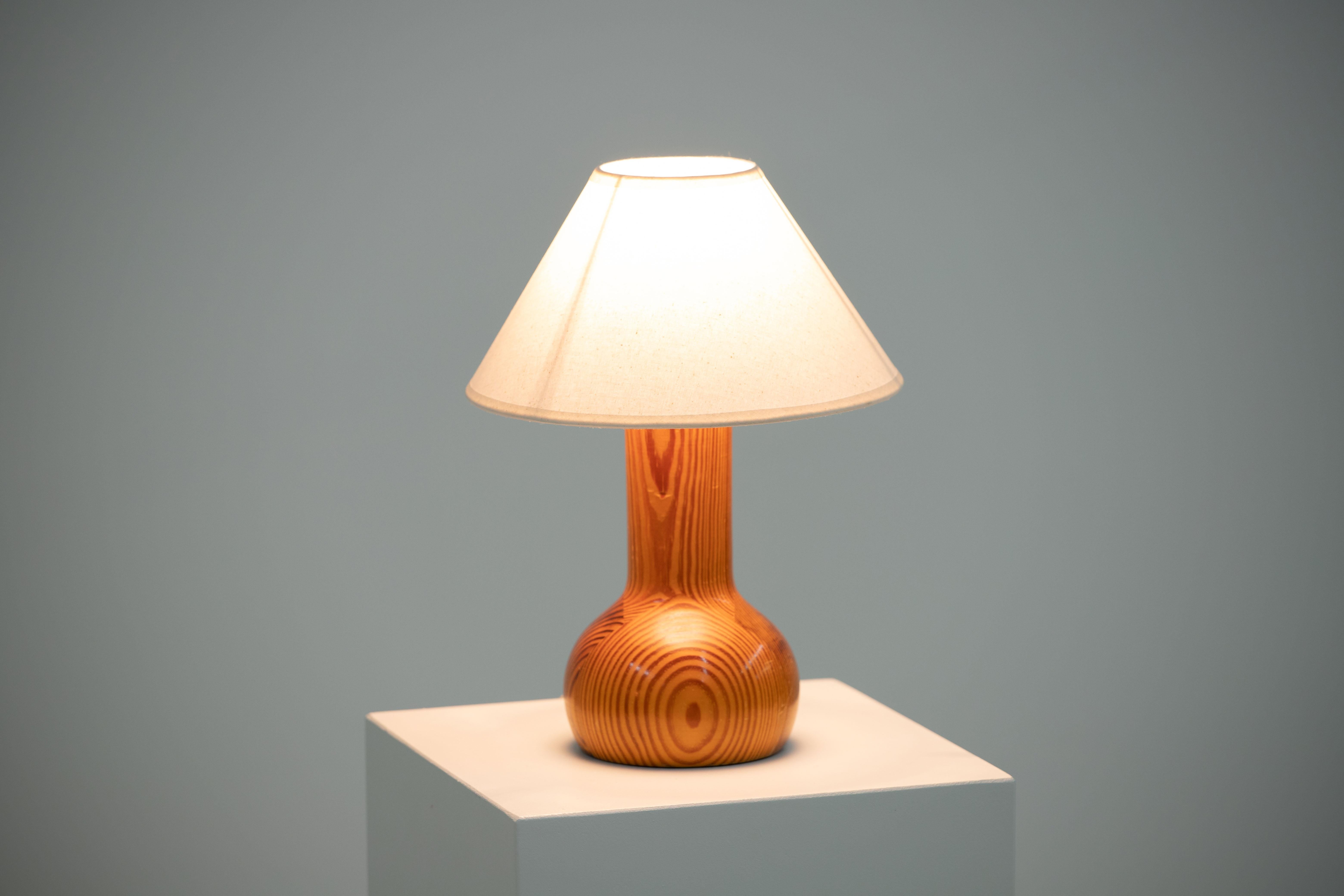 Introducing a captivating mid-century table lamp in solid pine, crafted in Denmark around 1960. This lamp showcases the iconic style reminiscent of Uno Kristiansson's designs.

Preserving its original charm, this lamp is in good general condition