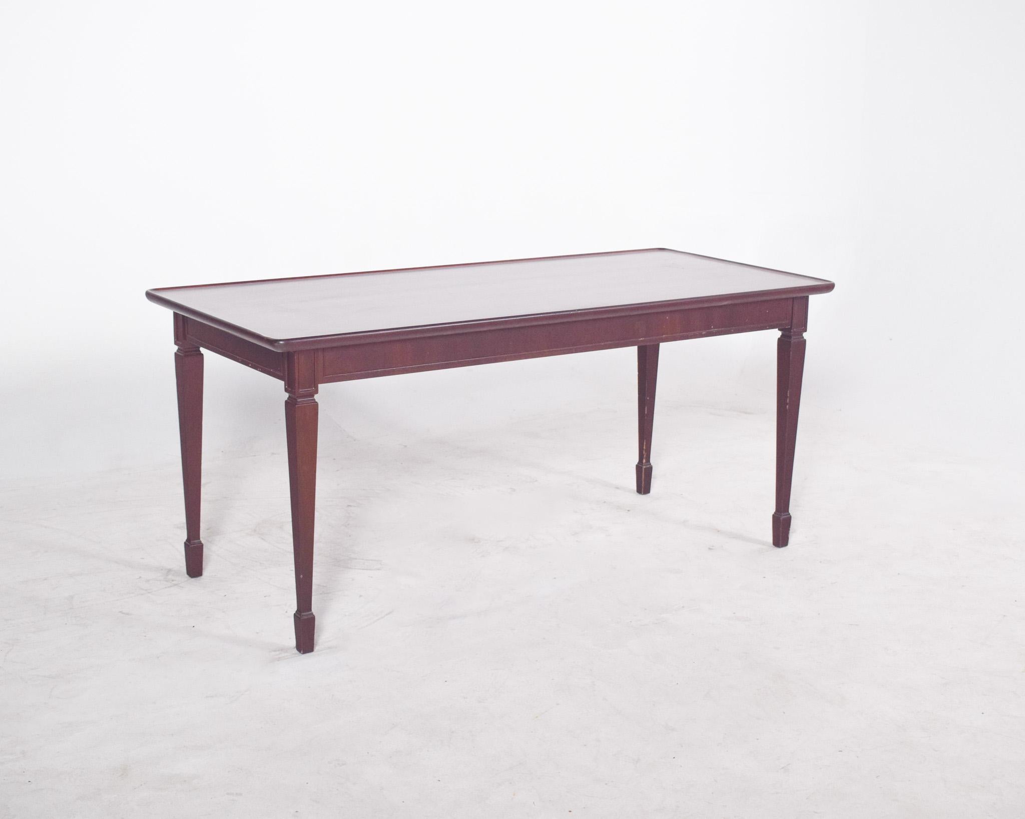 Rectangular side table in dark wood. It has a polished finish, with gently rounded corners on the top, which visually softens its presence and reflects beauty.
The bevelled and slightly tapered legs, with discreet carvings at the top, reinforce the