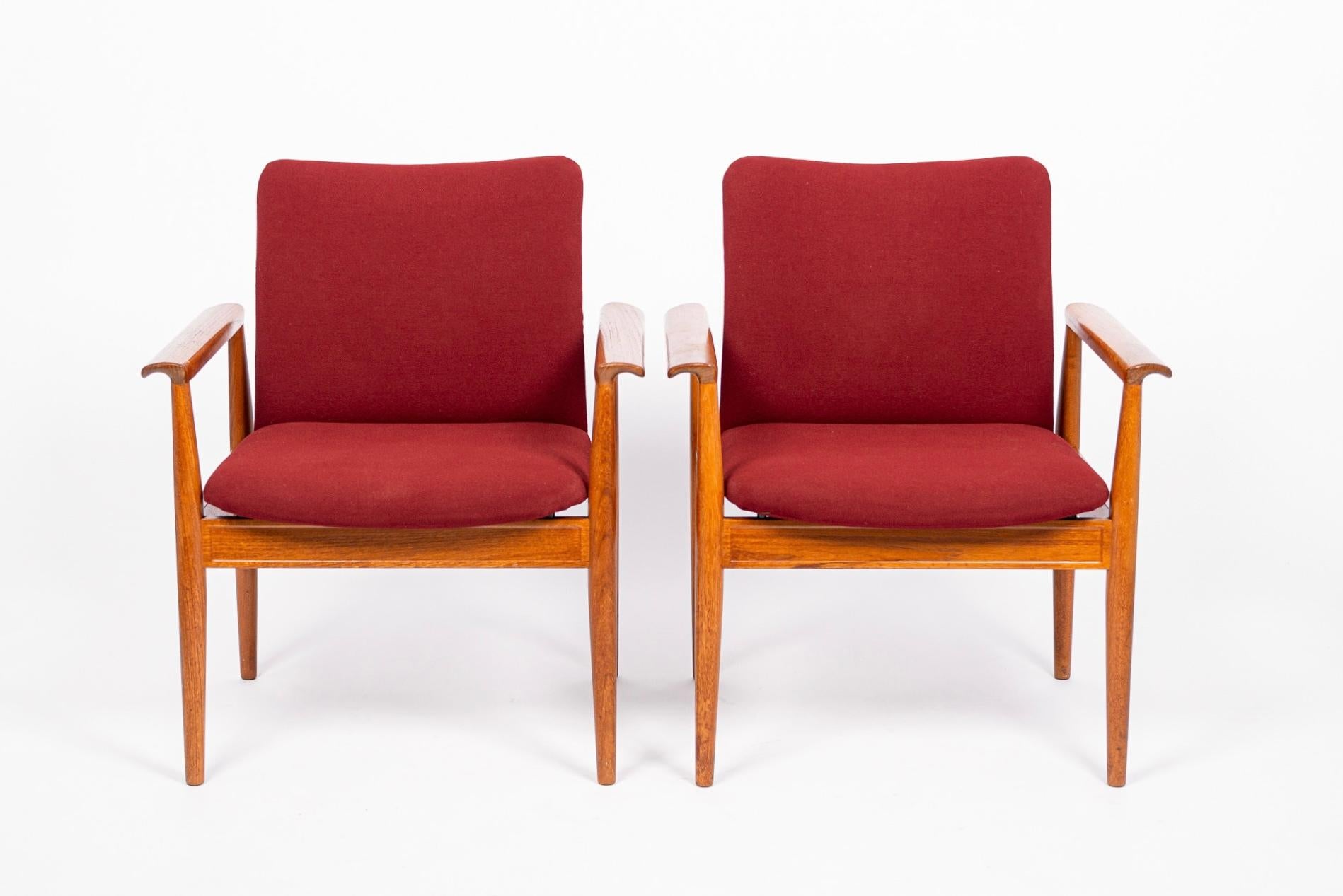These gorgeous vintage mid century modern Model 209 Diplomat chairs were designed by Finn Juhl in the 1960s and manufactured by France & Daverkosen. This sophisticated pair of chairs are expertly crafted from solid teak wood with original upholstery