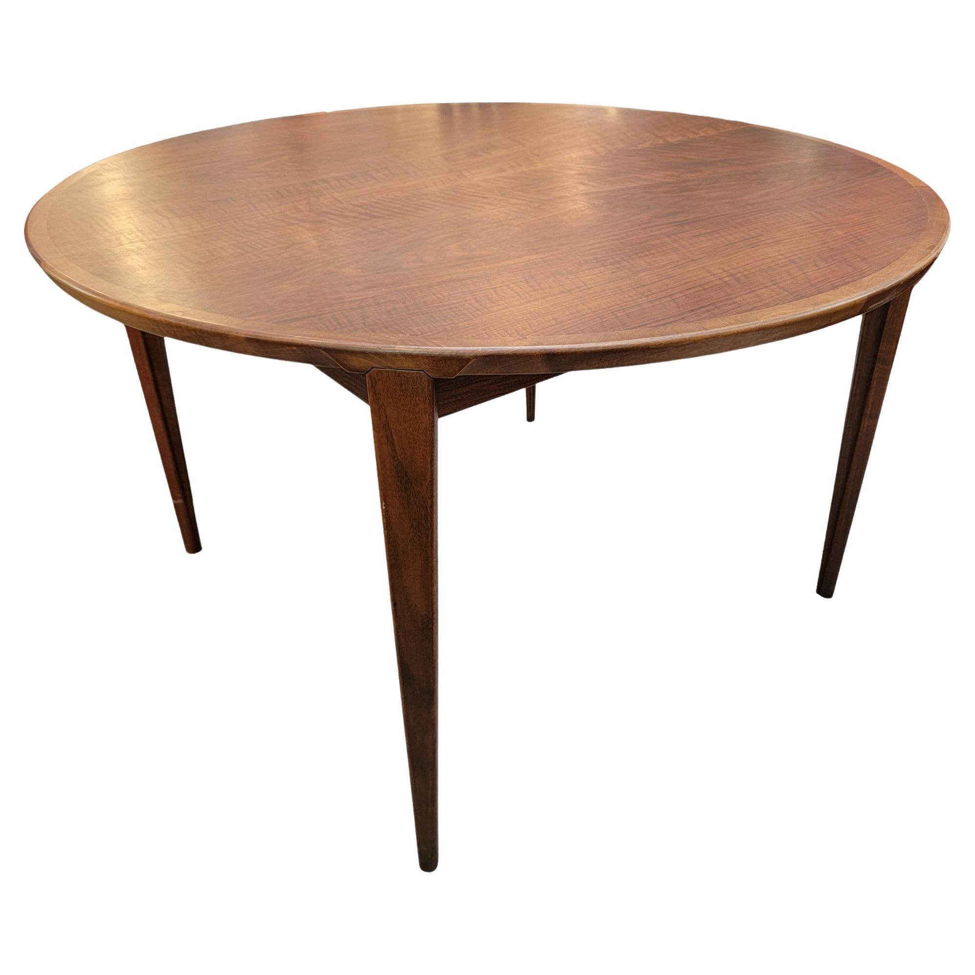 Beautiful red hue dinning table with beautiful grain on the table. The center opens to expose the extra leaf of this table. The leaf is folded in held under the table top and is is held up by 2 smaller pieces of wood. 
When connected the center leaf