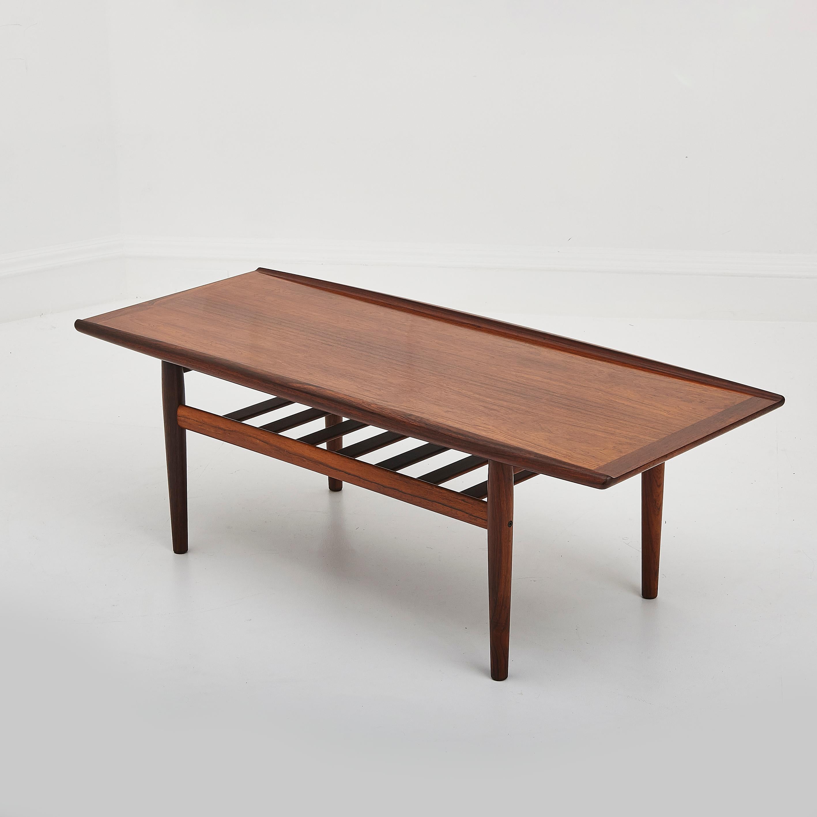 A stunning example of mid-century modern design, this Danish rosewood coffee table by renowned designer Grete Jalk for Glostrup effortlessly combines elegance with functionality. 

Crafted in the 1960s, this exceptional piece showcases the