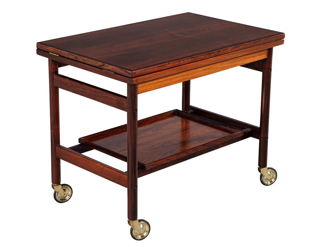 Elevate your entertaining experience with this exquisite mid-century Danish bar trolley, designed by the renowned Kurt Østervig for Jason Møbler, made in Denmark circa the 1960s. This stunning piece combines functionality with timeless elegance,