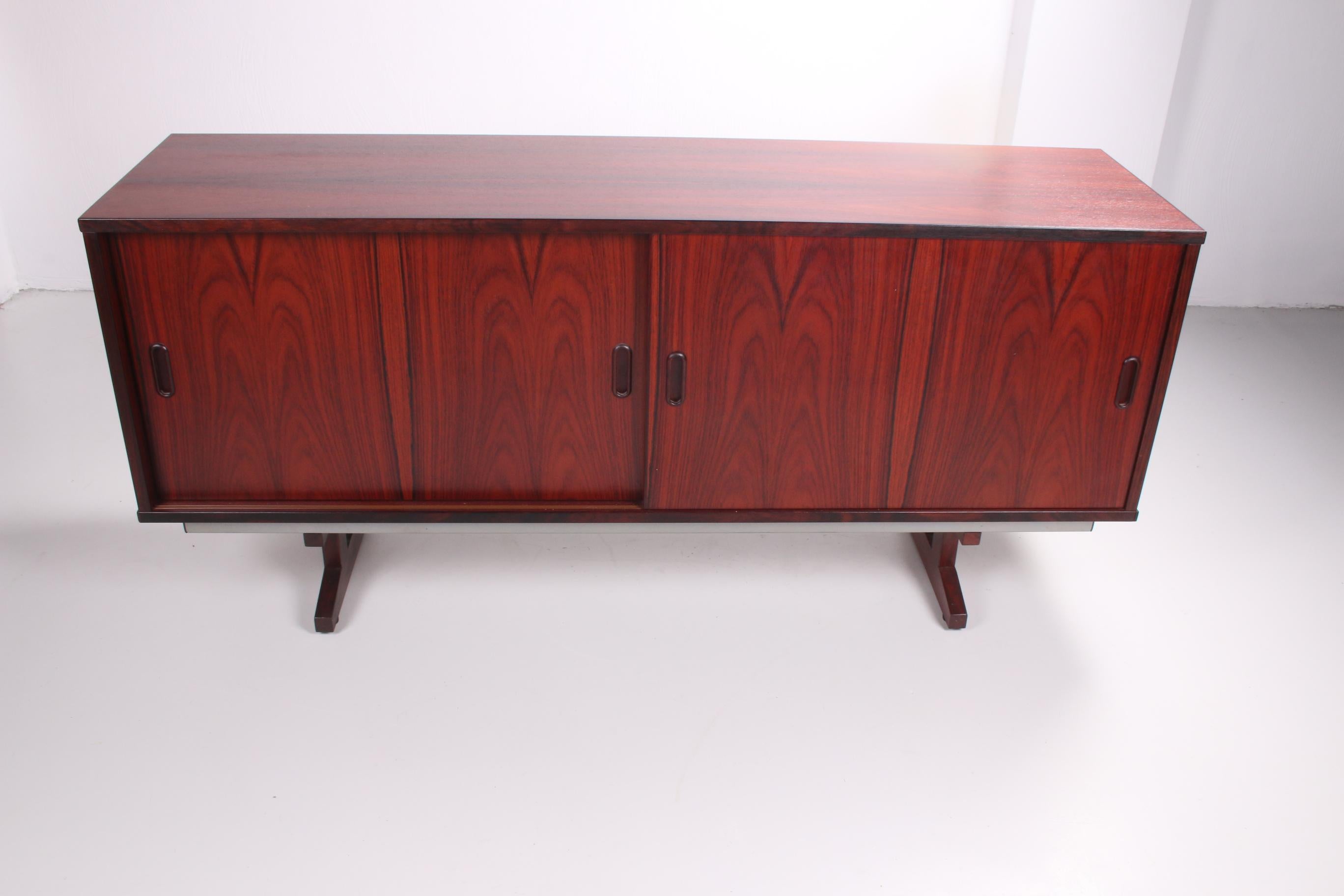 This beautiful cabinet is made with darkwood. It will be a wonderful addition to any interior, warming up the room with it's deep brown-red colour. 
Behind the sliding doors are two bigger shelves and five drawers. This means it has more than enough