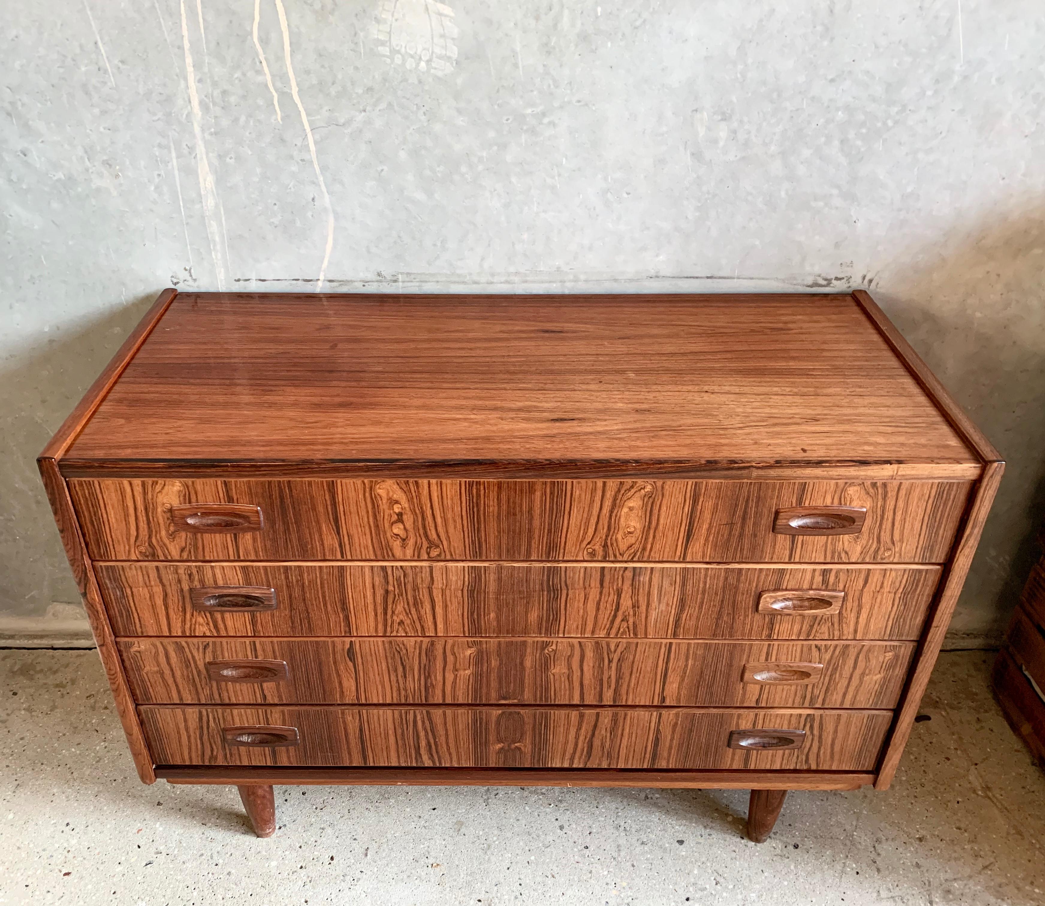 Chest of drawers in rosewood featuring four drawers and tapperes legs.