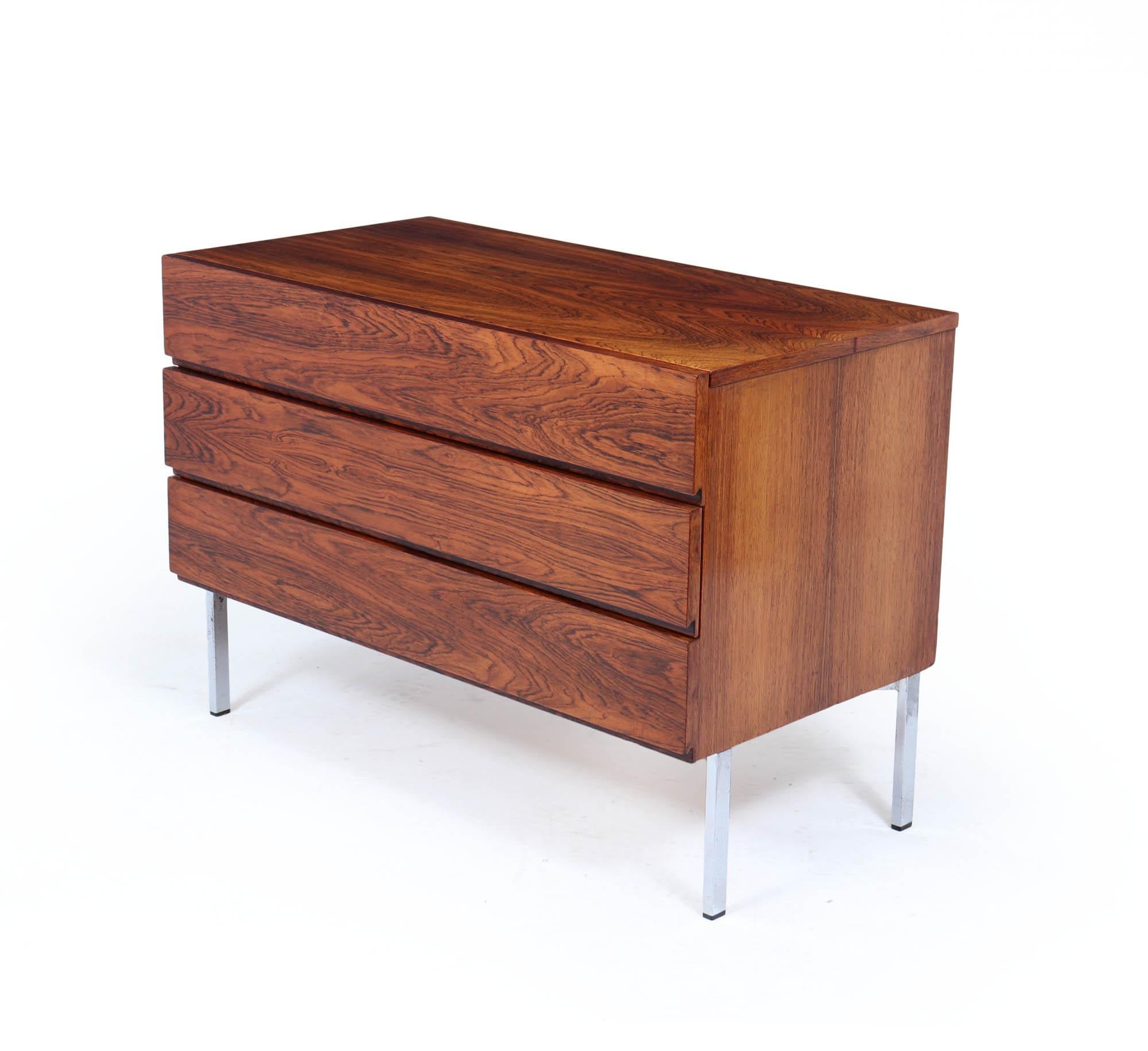 Una llamativa cómoda danesa moderna de mediados de siglo diseñada en la década de 1960. Fabricada en madera de palisandro muy labrada, esta pieza compacta pero impactante ofrece un elegante minimalismo equilibrado con un rico veteado y color