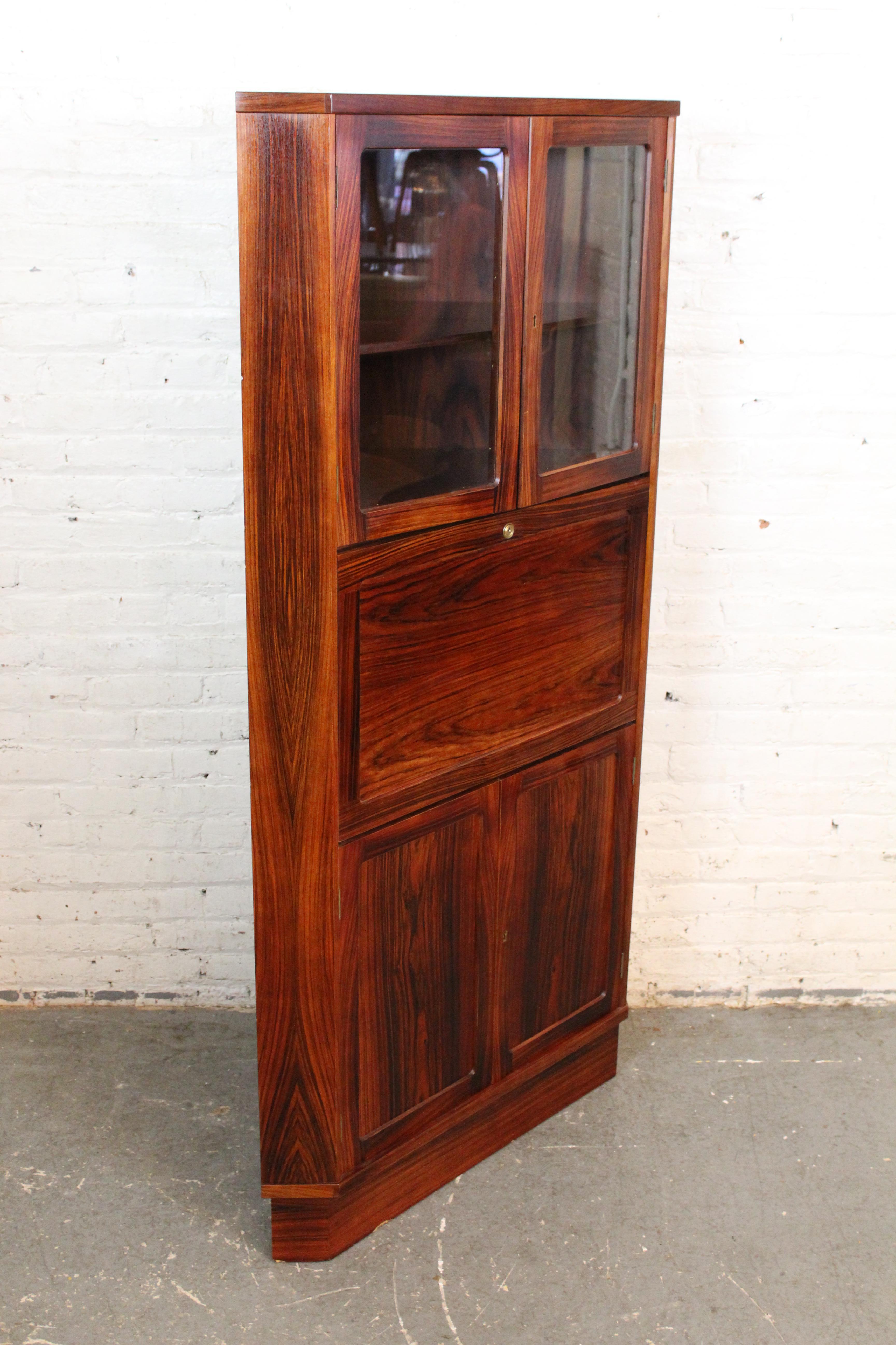 Discover the appealing practicality of mid-century Danish modernism with this wonderfully unique corner secretary produced by Vinde Møbelfabrik of Skive, Denmark. With stunning waves of rosewood grain, this 3-sided Scandinavian masterpiece stands