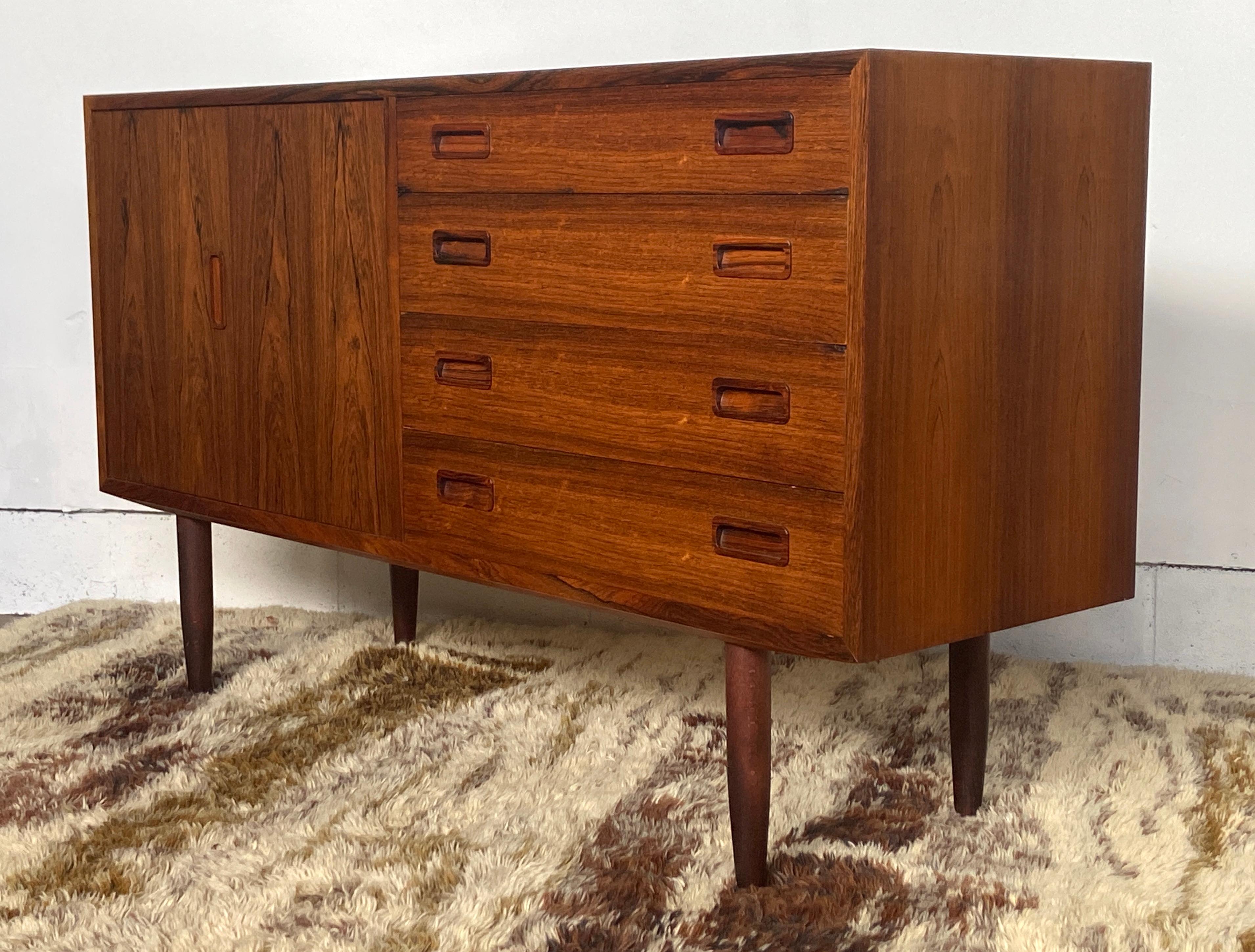 Bellissimo comò - credenza in palissandro danese di metà secolo di Carlo Jensen per Hundevad. Ha un'ottima porta bifold sul lato sinistro che si apre su un mobile con ripiani regolabili, mentre il lato destro ha quattro cassetti con tiretti
