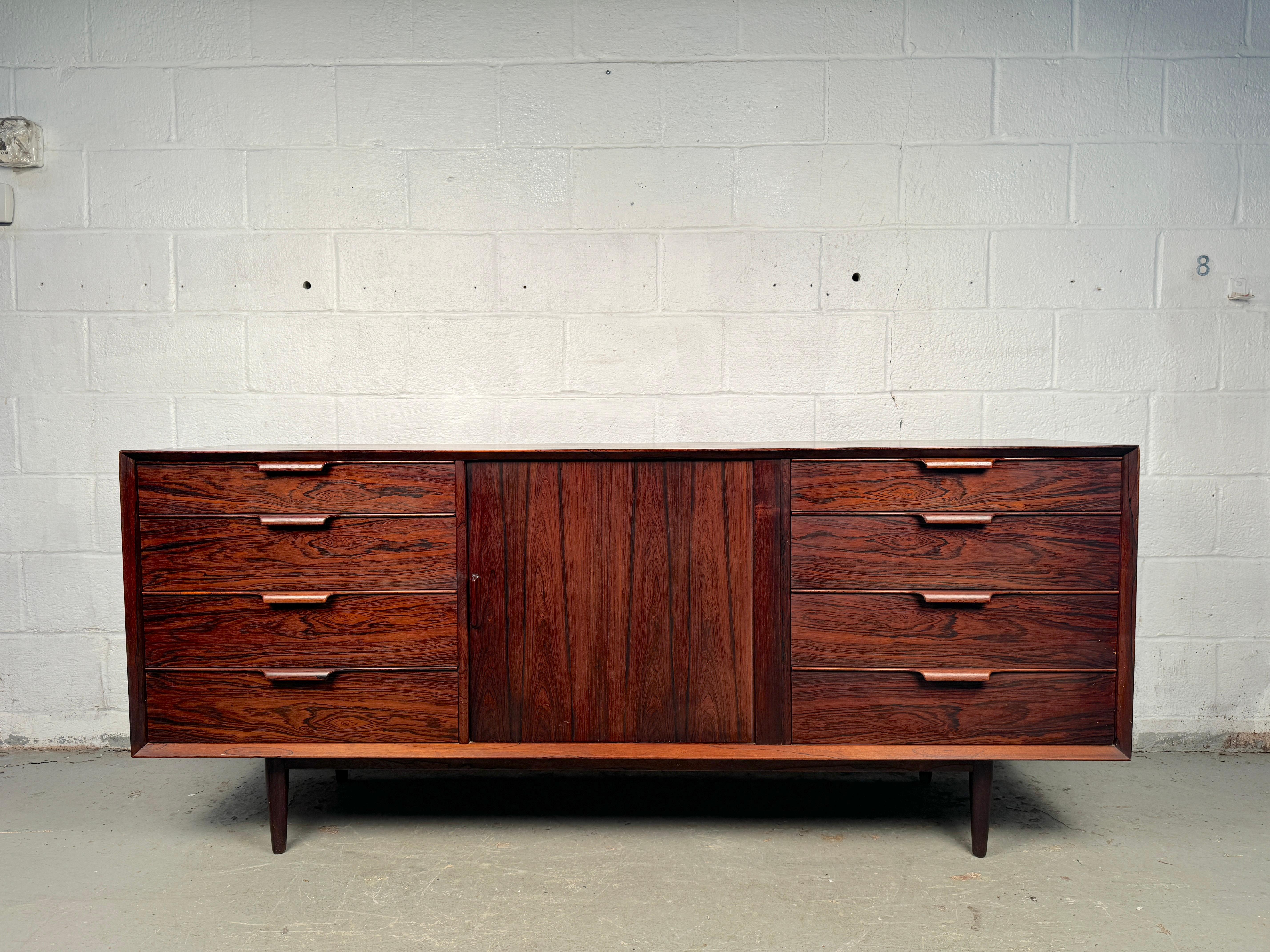 Diese Kredenz aus dänischem Palisanderholz verleiht Ihrem Interieur eine besondere Note. Sie verkörpert Luxus, Tradition und fachmännische Handwerkskunst. Dieses Sideboard aus reichhaltigem, schön gemasertem Palisander bietet sowohl eine auffällige
