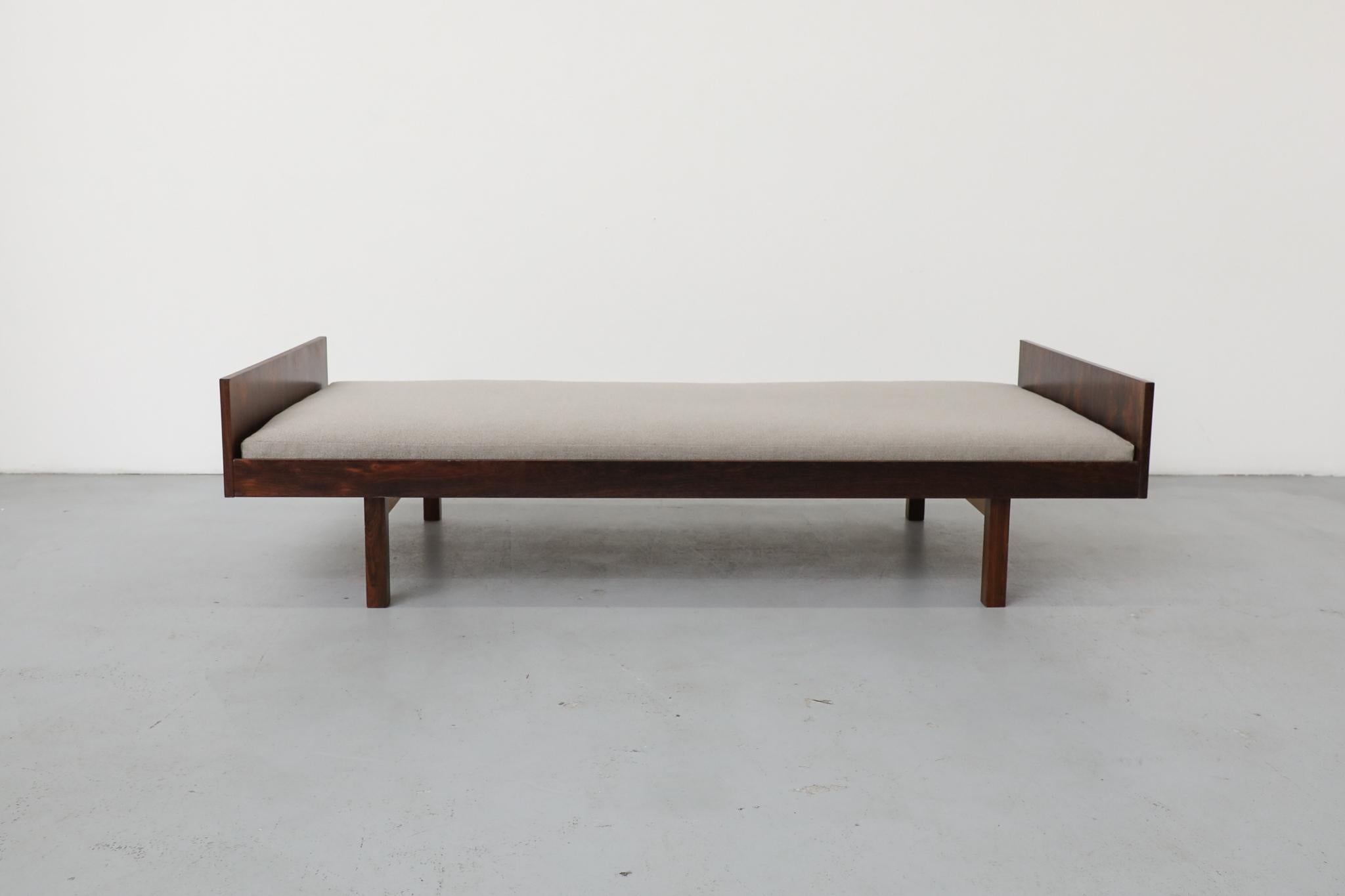 Questo bellissimo daybed danese di metà secolo, prodotto da Horsnaes Møbler negli anni '60, è uno splendido esempio di raffinato design scandinavo. Il pezzo cattura immediatamente l'attenzione con la sua ricca cornice in palissandro, che mette in