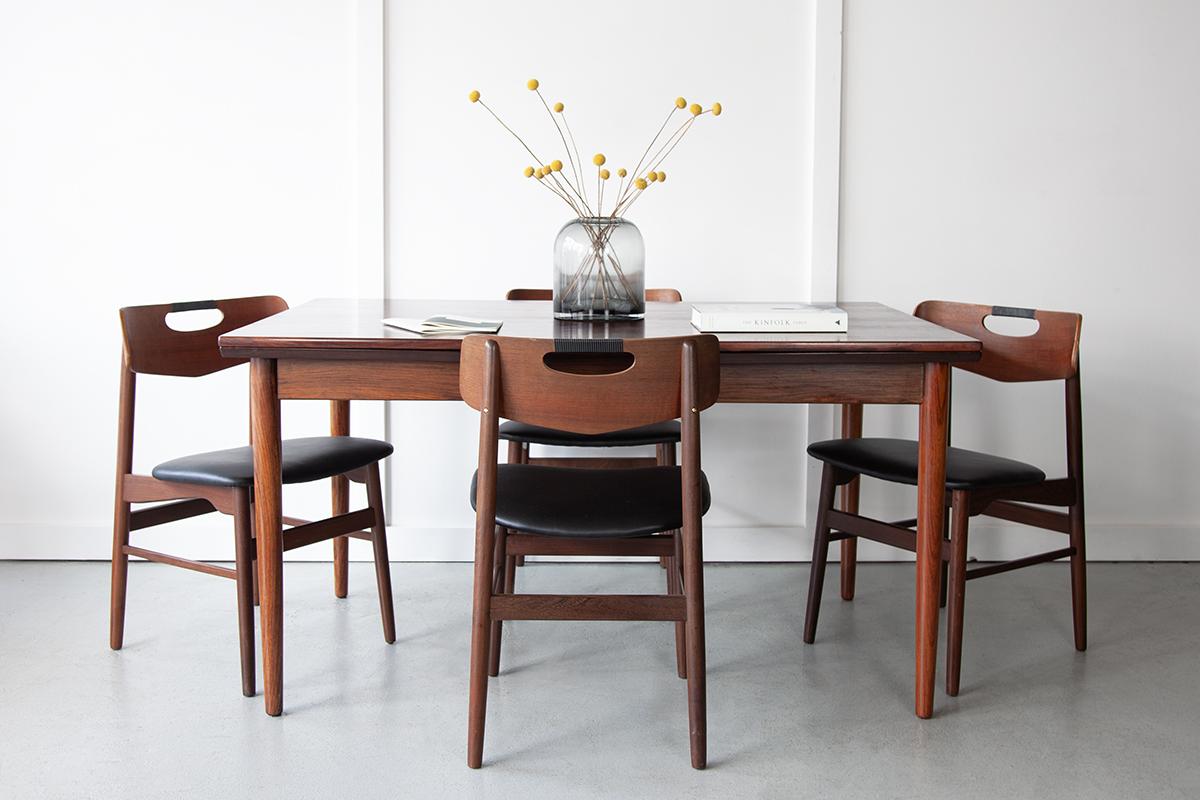 A beautiful and generously sized rosewood dining table from Denmark with elegant tapered legs and two extending legs which pull out, one by one, from beneath the table top at either end allowing for guests of up to 10 to sit together.  
