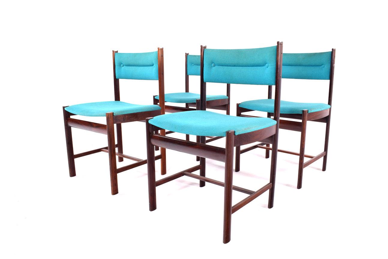 Mid Century set of four Danish dining chairs, each boasting a rich rosewood structure that exemplifies the classic design principles of the era. The wood's deep, chocolate hues are complemented by the distinctive grain patterns typical of rosewood,