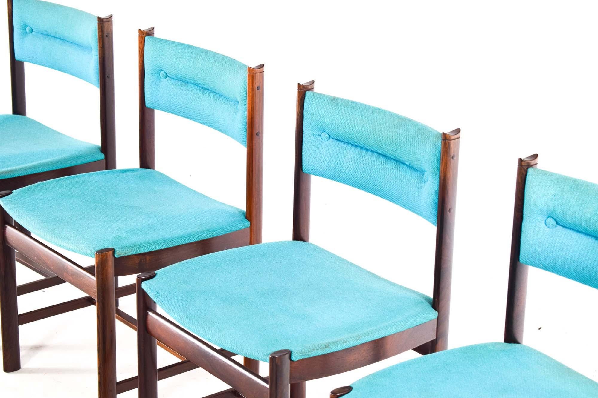 Set di quattro sedie da pranzo danesi della metà del secolo scorso, ognuna delle quali vanta una ricca struttura in palissandro che esemplifica i principi classici del design dell'epoca. Le profonde sfumature color cioccolato del legno sono