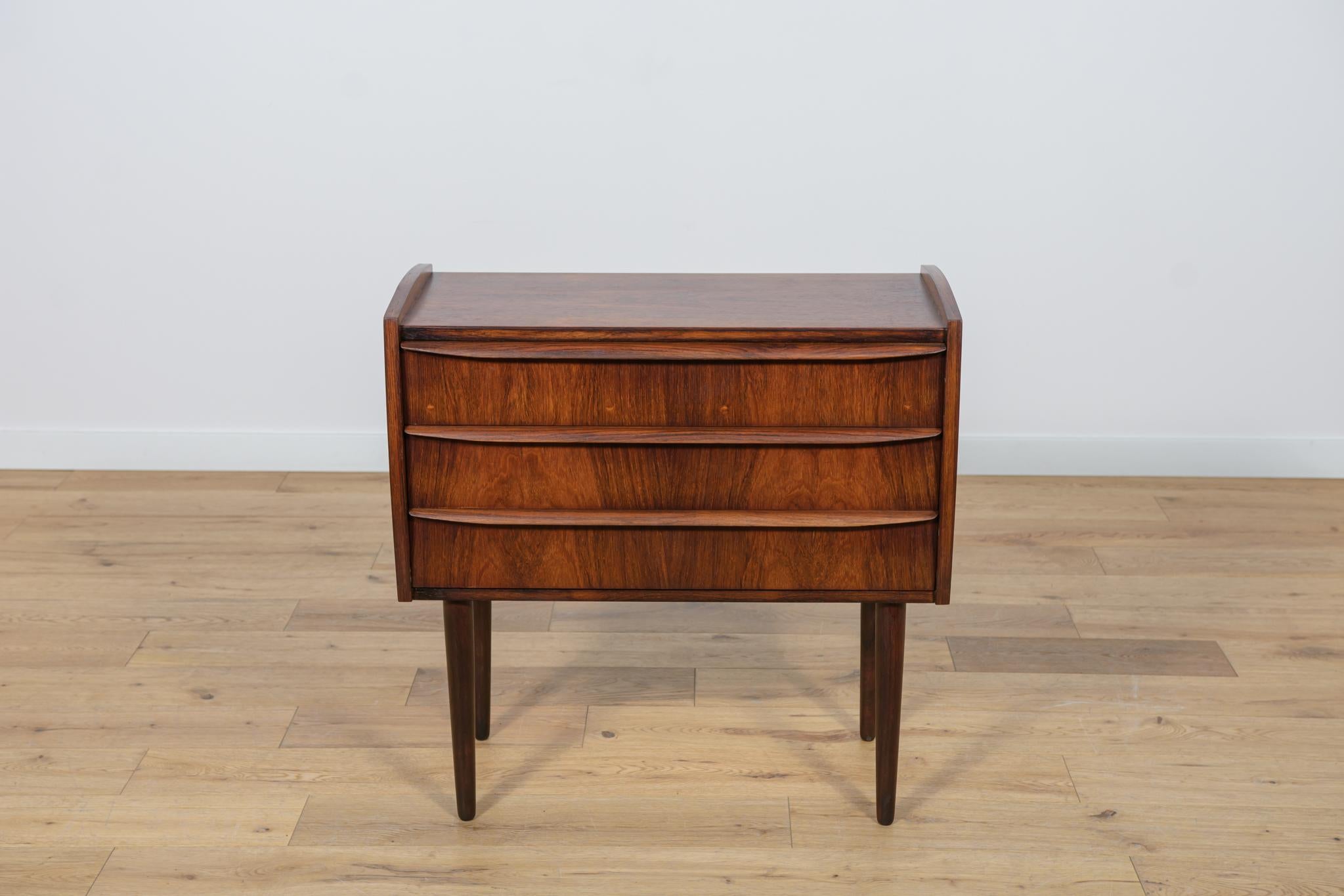 Mid-Century rosewood dresser made during the 1960s in the Denmark. The dresser has profiled handles. The dresser consists of 3 drawers with profiled handles.
The dresser has been cleaned with old surface, painted rosewood stain and finished with