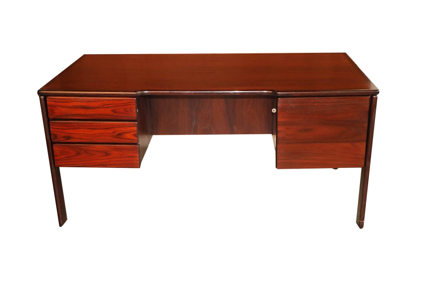 Beautiful remarkable statement in design and craftsmanship. This large midcentury rosewood executive size desk by Bornholm, precisely crafted in exceptional rosewood grain wood, with a fully finished back the finished back side makes this desk ideal