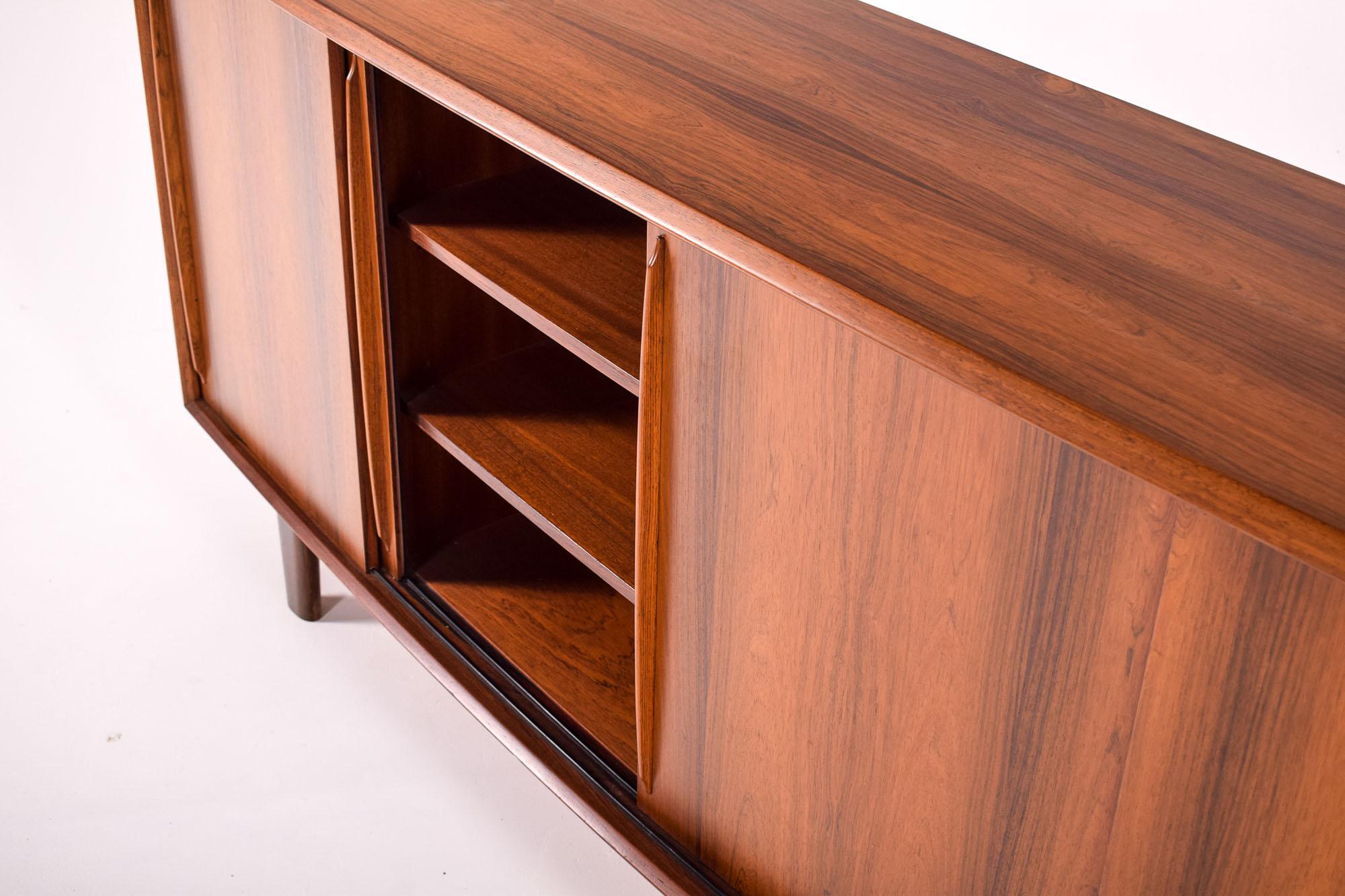 Ce buffet, conçu par H.P. Hansen, est une pièce exquise qui incarne l'union de la forme et de la fonction, une caractéristique du design des meubles du milieu du siècle. Les lignes épurées et la riche chaleur du bois soulignent l'attention portée