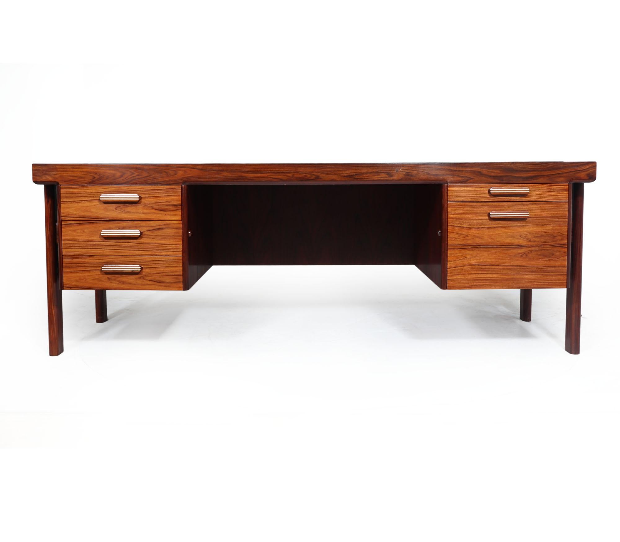 Danish desk by Arne Vodder 
A midcentury Danish desk designed by Arne Vodder and produced in Santos rosewood in the 1970s. The desk has tree drawers to the left and a pen tray with slide to the right and a large deep filing drawer below each having