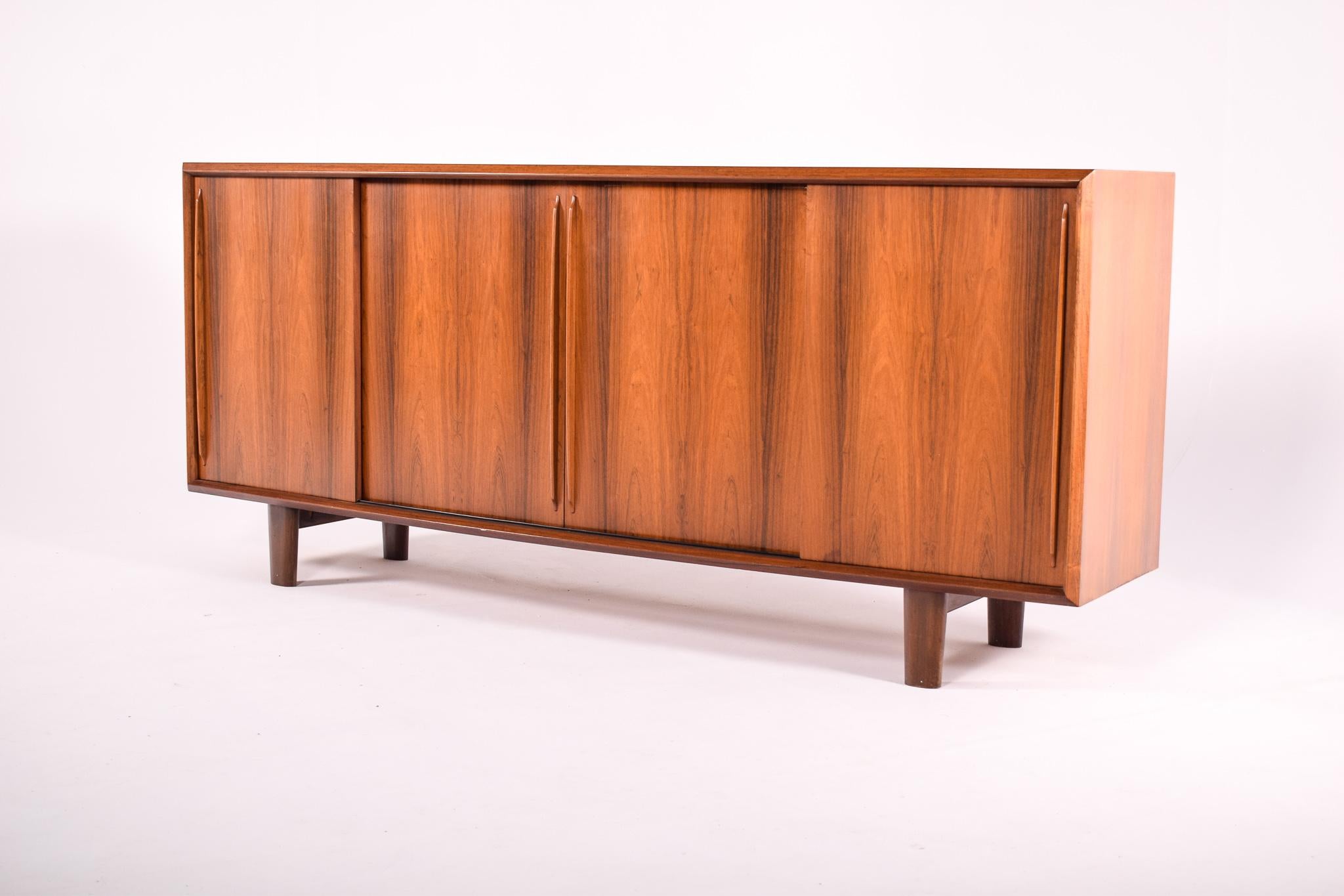 This sideboard, designed by H.P. Hansen, is an exquisite piece that embodies the union of form and function, a characteristic hallmark of mid-century furniture design. The clean lines and the rich warmth of the wood highlight Hansen's attention to