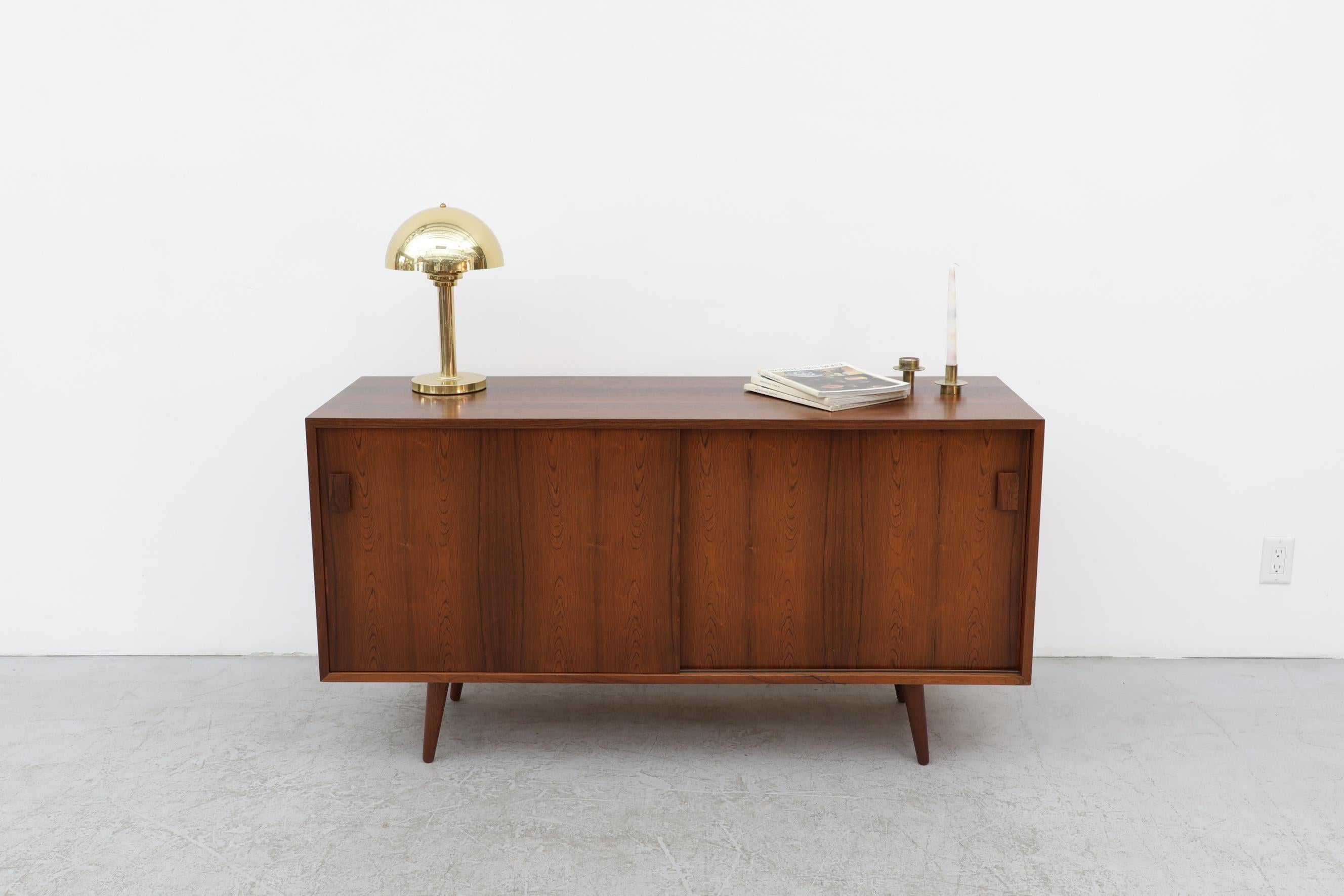 Small Danish rosewood sideboard by Dammand & Rasmussen Møbelfabrik. A striking design with a unique wood grain and prominent rectangular carved handles. In original condition with visible patina and some scratching wear is consistent with its age
